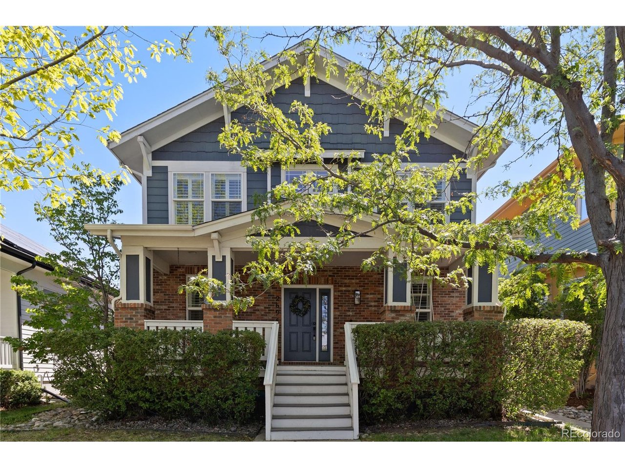 Experience the quintessential Central Park lifestyle in this stunning residence, perfectly positioned on a picturesque tree-lined street just a half-mile from the iconic Stanley Marketplace. A charming covered front porch provides a warm welcome, leading into a refined entryway where premium plantation shutters and a multi-zone, built-in ceiling sound system immediately set a sophisticated tone. To the right, a formal dining space stands ready for elegant hosting, while the opposite side of the foyer offers a rare main-floor bedroom and full bathroom-perfect for guests or a home office. The back of the home opens into a bright, social hub where the kitchen flows seamlessly into the living room. The chef-inspired kitchen features sleek Silestone countertops, stainless steel appliances, a pantry, and a large island with a breakfast bar. In the living room, a cozy gas fireplace and a built-in wine cooler make for the ultimate relaxation spot. Upstairs, the primary suite is a true showstopper, boasting a private five-piece en-suite bath and a massive, professionally designed custom walk-in closet. Two additional bedrooms and a well-appointed full bath complete the upper level. The finished basement is an entertainer's paradise, hosting a massive media room equipped with a built-in sound system for the ultimate movie night. This lower level also features a fifth bedroom, a versatile bonus room, a 3/4 bath, and a laundry room. Step outside to a sun-drenched backyard oasis featuring multiple sitting areas and a built-in outdoor gas fireplace-the perfect setting for Colorado evenings. Major system upgrades include a new 2025 roof, high-efficiency dual-fuel HVAC system (2023), and owned 7.44 kW solar panels with no lease. With a detached two-car garage and a location that puts world-class dining, parks, and trails at your fingertips, this home is the perfect blend of luxury and location.