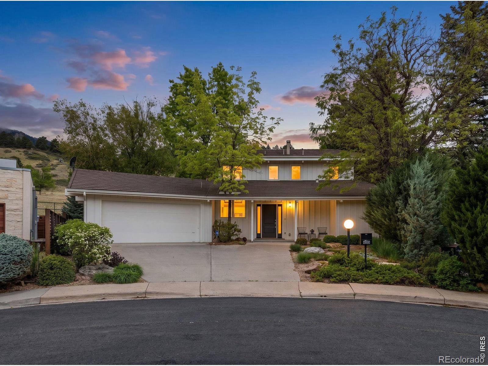 Tucked away at the end of a quiet cul-de-sac and backing directly to open space, 303 Hollyberry Lane is a rare Boulder retreat where privacy, architecture, and access to nature come together seamlessly. With miles of hiking and biking trails just steps from your door and unobstructed dramatic Flatiron views, this home offers an extraordinary connection to the outdoors while feeling warm, grounded, and special while inside.Rich in character and timeless design, the home showcases rustic wood beams, soaring vaulted ceilings upstairs, hardwood floors, moss rock fireplaces, Juliet balconies, and expansive windows that frame the surrounding landscape from nearly every room. The interiors feel both elevated and relaxed - filled with natural light, organic textures, and inviting gathering spaces.The upper level features a stunning primary suite with sweeping Flatiron views and its own gas fireplace, along with two additional bedrooms and a full bath. On the main level, the updated kitchen opens effortlessly to the dining and living spaces, where French doors lead to the flagstone patio and open space beyond. A fourth bedroom or office with a 3/4 bath offers flexibility for guests or work-from-home living, while an additional flex space, a mudroom with laundry, and an attached two-car garage complete the thoughtful layout.Modern comforts include two-zone heating and central air conditioning, abundant storage throughout the garage and exterior closets and efficient, intentional living spaces without excess. Whether you're entertaining after a day on the trails, enjoying peaceful mornings overlooking the hikers in the distance, or simply soaking in the warmth and personality of the home, every detail fits perfectly for comfortable Boulder living.303 Hollyberry Lane is more than a home - it's a private sanctuary immersed in nature, with the best of Boulder just outside your door. A once in a lifetime chance to make life so incredibly special.
