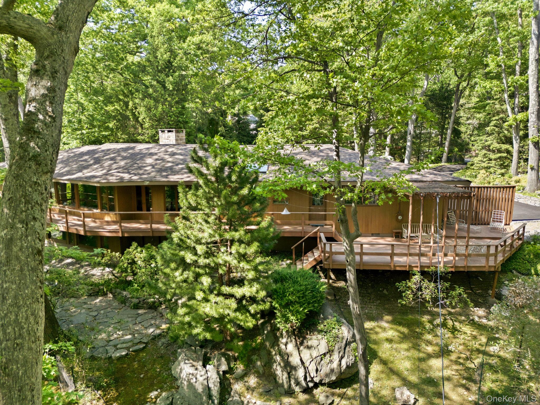 Built in 1962 in the spirit of Usonia, this exceptional mid-century modern residence is being offered for the first time by its original owners. Designed through a unique collaboration with renowned architect Edgar Tafel, Frank Lloyd Wright's longtime apprentice, the home showcases soaring lofted ceilings, a dramatic custom walnut architectural ceiling feature, striking stone accents, and a stunning floor-to-ceiling stone fireplace. Privately set on 2.3 acres on a quiet dead-end road, this architectural gem offers 3 bedrooms, 3 full baths including a primary ensuite, a den, a finished walk-out lower level and expansive decking. An attached two-car garage with a bonus of a separate car barn with additional space for 6 cars, ideal as an artist's studio, workshop, or creative retreat. A rare opportunity to own an architecturally significant home that beautifully honors the principles of mid-century modern design while preserving the vision of its original owners. A truly special offering where architectural history and timeless design come together. Home as art.
