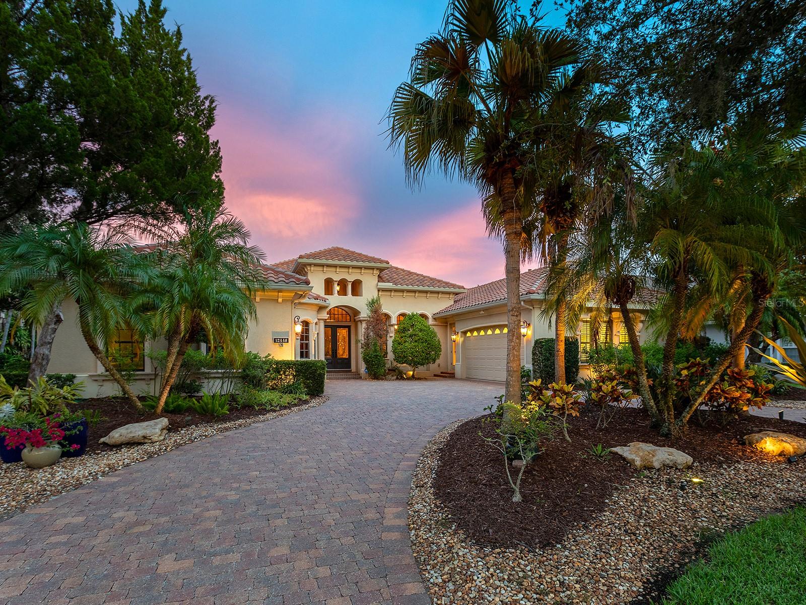 Under contract-accepting backup offers. Nestled amidst 0.46 acres of lush conservation is this meticulous former Lee Wetherington model home adorned with opulent upgrades and custom elements in every room.  Located in the upscale Highfield neighborhood within Lakewood Ranch Country Club is this Addison model; offering an inviting yet spacious residence with over 4,700 SF for every member and lifestyle, including formal and casual living and dining spaces, upgraded kitchen, two separate office spaces, second-level bonus room retreat, luxurious primary bedroom suite, and 3 additional guest bedrooms, 2 guest bathrooms plus 2 powder baths.  You are welcomed home to this magnificent residence with a large circular paver driveway and a split 4-car garage with each bay having direct access to the home.  The foyer opens from double glass doors and showcases the floor-to-ceiling detailed and custom elements you’ll find throughout this residence – custom ceilings with beams and coffers, architectural columns, custom painted walls, solid core doors, and a warm welcoming color palette.  The formal living room highlights the garden-like lanai and conservation with a large aquarium window, custom coffered ceiling, and stone-surround gas fireplace.  Enjoy your meals in the formal dining room with tented ceiling and custom wine bar featuring glass display cabinetry, bar fridge, and wine bottle shelving.  The carefully designed kitchen offers custom cabinetry with spice racks, display cabinets, cookbook shelves, pot and pan drawers, and gorgeous moldings, plus a central island with prep sink.  Enjoy upgraded appliances from the gas cooktop with pot filler, dual dishwashers which are great for entertaining and large dinners, and paneled refrigerator.  Casual meals are a delight from the breakfast bar or the dinette with aquarium window.  The family room embraces the Florida lifestyle of seamless indoor and outdoor entertaining with disappearing corner sliding glass doors to the lanai with a cozy fireplace, dining area, full outdoor kitchen, wood ceilings, and windows overlooking the preserve.  Surrounded by verdant gardens, the gas heated saltwater pool and spa is the ideal place to cool off or sunbathe on the sunshelf.  When it’s time to work you have the choice of two expertly outfitted studies, both equipped with custom bookshelves and built-in desks.  The primary suite with wood floors is bathed in natural light from the large windows and sliders with serene conservation views.  The spa-like bathroom spaciously offers privacy for owners with dual walk-in closets in the hall, split vanities, soaking tub with whirlpool, walk-in shower, and a private courtyard with outdoor shower.  Guests will find comfort in 3 guest bedrooms, large enough for a king bed, plus a jack & jill bathroom, and a dual function pool and full bathroom.  The second level is the ideal space for fun with a large bonus room that has plenty of space for games, billiards, movie zone, play room, fitness area, teen retreat and more, and you’ll never want to leave with a private balcony, powder bath, and dry bar.  Appreciate a state-of-the-art fitness center, clubhouses, junior Olympic-sized pool, four 18-hole championship golf courses, tennis and pickleball, and more by becoming a member of the Lakewood Ranch Country Club. Lakewood Ranch is the top multi-generational community in the country for 7 years in a row with award-winning shopping, dining, A-rated schools, parks, and nearby beaches.