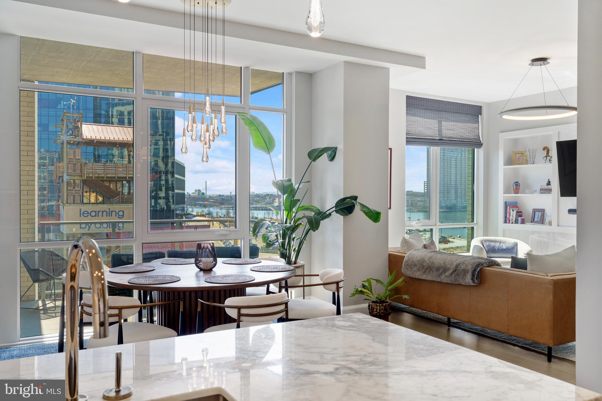 Welcome to waterfront, elevated city living at The Liberty Harbor East, one of the most sought-after boutique residences in Harbor East, where modern design meets vibrant waterfront energy.This extraordinary fifth-floor residence, built in 2019, offers 1,163 square feet of refined living space with one bedroom, one full bath, and a versatile den. Recently enhanced with thoughtful, high-end upgrades, the home now features fresh designer paint, new modern lighting with Lutron smart lighting system, and custom built-ins that elevate both style and functionality. The layout has been reimagined with the removal of the wall between the den and living area, creating an even more open and expansive living space, perfect for today’s lifestyle. From the moment you enter, you’re greeted by soaring 10-foot ceilings and dramatic floor-to-ceiling windows that flood the home with natural light while showcasing breathtaking southwest views of downtown Baltimore. New custom blinds, fully integrated with Alexa for smart home convenience, add both luxury and ease of living.The living and dining areas flow seamlessly into a chef’s kitchen featuring sleek Italkraft cabinetry, premium Thermador appliances, and a striking Calacatta marble waterfall island, ideal for entertaining. Tucked privately beyond the foyer, the spacious primary suite has been elevated with a stunning custom wood-paneled accent wall and offers access to a private balcony overlooking the iconic Inner Harbor. The spa-inspired bath is a true retreat, featuring Carrara marble, Kallista and Kohler fixtures, an expansive walk-in shower, and a custom dual vanity, while the oversized walk-in closet provides abundant storage.  Additional upgrades include a whole-house water filtration system and a new hot water heater, ensuring comfort and peace of mind. Residents of The Liberty enjoy a full suite of resort-style amenities, including a rooftop infinity pool with cabanas, a state-of-the-art fitness center and yoga studio, pet park with agility equipment, and beautifully designed social spaces such as a clubroom with indoor/outdoor bar, private dining rooms, and a concierge lounge. Additional conveniences include a secure package room, ButterflyMX smart intercom system, conference rooms, EV charging stations, and garage parking availability. Adding to the unmatched lifestyle, The Liberty offers direct access to a flagship Whole Foods Market, making everyday living effortless. Just steps away, Harbor East is home to some of Baltimore’s finest dining, boutique shopping, and scenic waterfront promenades, placing the very best of the city right outside your door. This is more than a home, it’s a lifestyle defined by luxury, convenience, and sophistication in one of Baltimore’s premier waterfront communities.