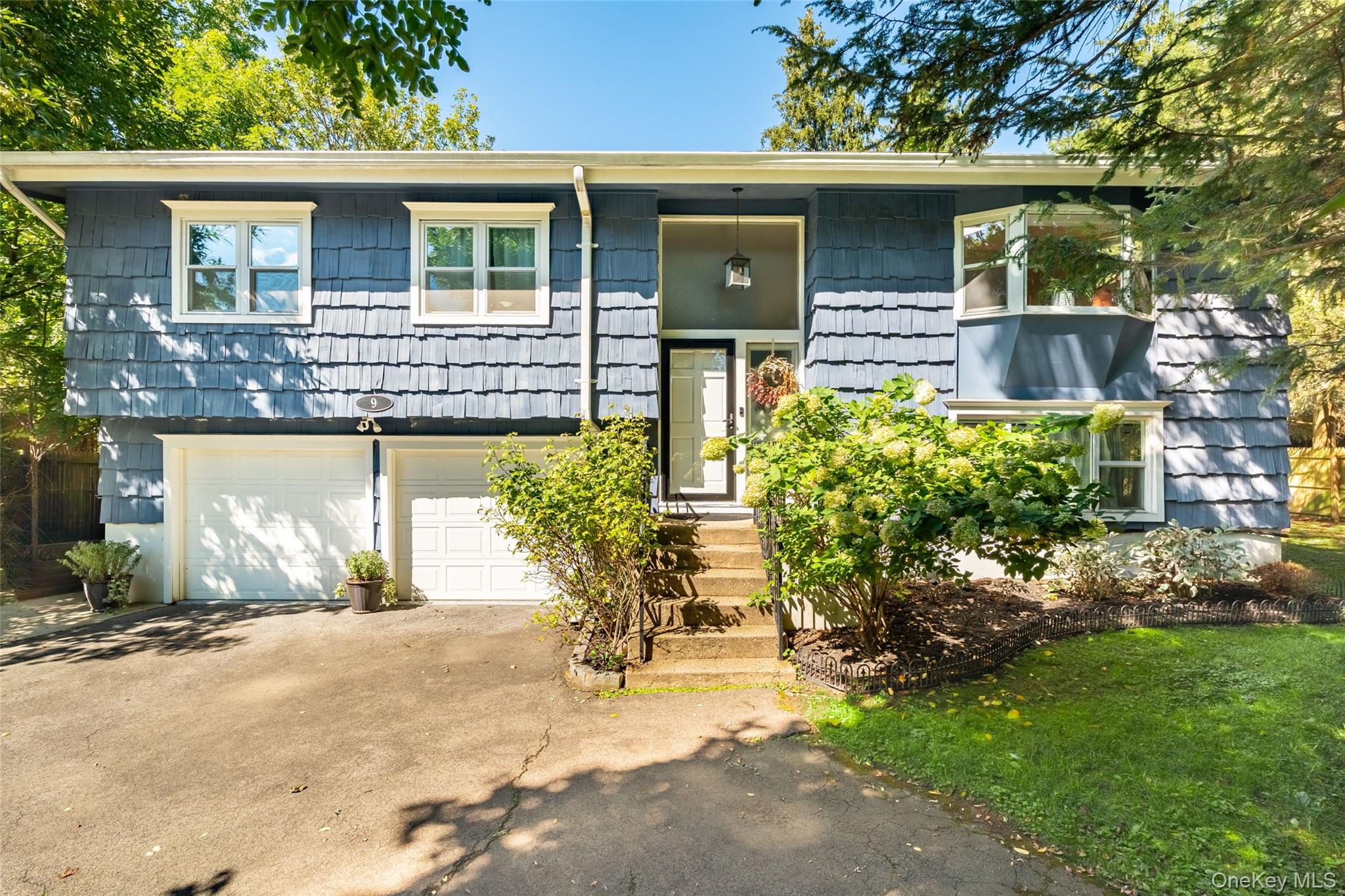 Welcome to 9 Brookdale Drive in Hartsdale, a beautifully renovated raised ranch offering style and comfort. This home features hardwood floors, abundant natural light, cathedral ceilings, and an oversized arched window. The updated kitchen boasts granite countertops, stainless steel appliances, a wall oven, and a sliding glass door leading to a cedar-enclosed rear deck. Spacious bedrooms include ample closets, with a primary suite featuring an en suite bath. The lower level offers a fourth bedroom, large open space, and a roomy mudroom. Enjoy a big backyard and a convenient location close to Metro North, shopping on Central Avenue, and all that Hartsdale has to offer.