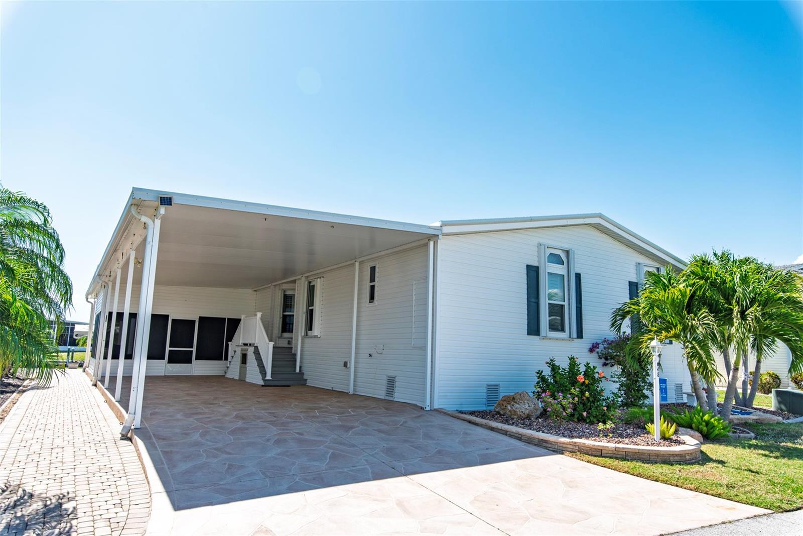 Located in the desirable 55+ community of Windmill Village, this beautifully maintained Jacobsen home offers approximately 2,300 square feet of spacious living with 3 bedrooms and 2 bathrooms. Inside, you’ll find generous room sizes, an open floor plan, and attractive laminate flooring throughout. The kitchen, completely renovated in 2018, is designed to impress with Samsung appliances, quality wood cabinetry with pull-outs, granite countertops, an oversized island, and reverse osmosis—ideal for both everyday living and entertaining. Numerous upgrades add value and peace of mind, including double-paned windows (2019), plantation shutters, accordion storm shutters, new siding (2024), new ductwork (2024), roof-over (2019), water heater (2024), and new screening on the front lanai (2024). The spacious primary suite features a full wall walk-in closet and an updated bath with a double sink vanity. A standout feature of the home is the expansive 30x14 Florida room overlooking the canal and Zyder Zee Marina, complete with plexiglass windows, custom roll-up shades, and a mini-split system for year-round comfort. Exterior highlights include an extra-wide driveway and carport with space for multiple vehicles, golf carts, and bikes, along with a second screened lanai and a large shed with an air-conditioned workshop. Waterfront amenities include a brick paver patio, covered boat lift, and private dock—perfect for enjoying the Florida lifestyle. The low HOA fee covers water, sewer, trash, lawn care, common area upkeep, and road maintenance, ensuring a truly hassle-free lifestyle. Windmill Village offers an active and engaging environment with two private marinas, a boat ramp, trailer storage yard, horseshoe pits, shuffleboard, bocce ball, billiards, indoor pickleball, a large community center, and numerous clubs. The pavilion by the heated pool provides a perfect setting for gatherings and social events. Located near Punta Gorda—voted “#1 Best Small Place to Live” by Money Magazine and Forbes—this home offers both comfort and convenience. The purchase price does not include the $18,285 buy-in share and bond, which is refunded upon resale. Don’t miss your chance to own this thoughtfully upgraded waterfront home—schedule your private showing today and start living your Florida paradise.