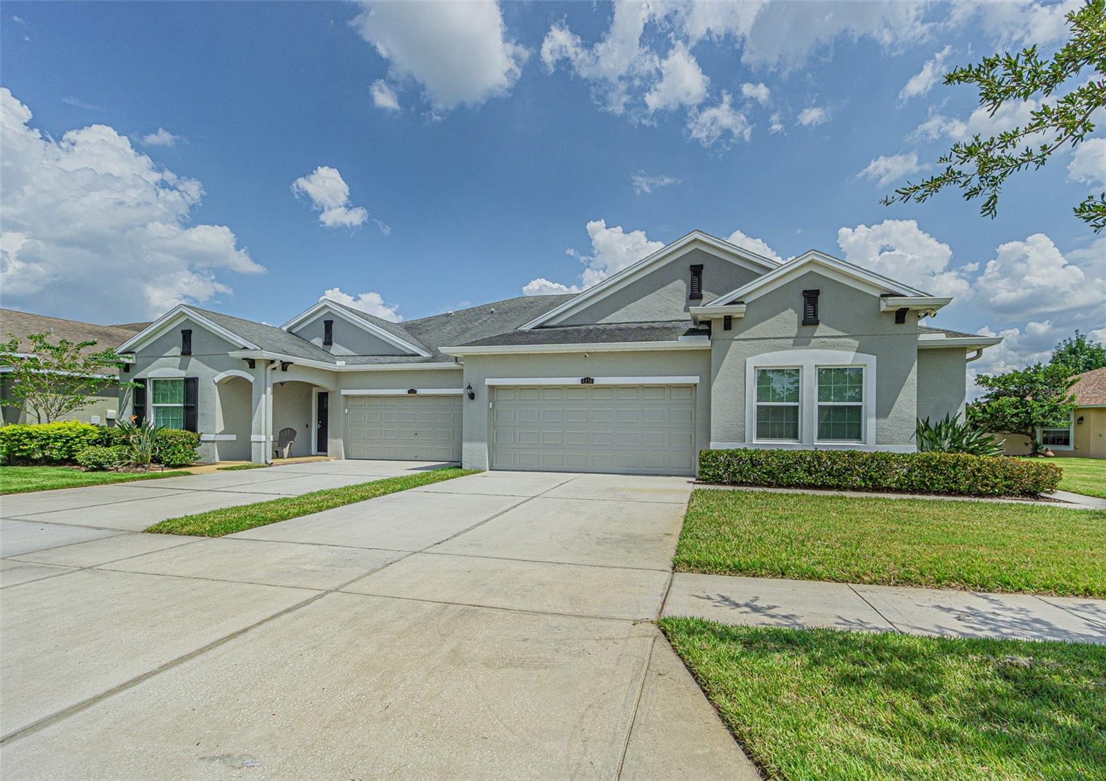 SERENE WATER VIEWS from your extended screened lanai in this Ashton Oaks maintenance-free villa!  With no CDD fees and low HOA dues, this spacious three-bedroom, two-bath “Magnolia” floor plan offers comfort, style, and convenience all in one.  Set on a generous pie-shaped lot with a large side yard, you’ll enjoy extra green space and privacy between homes.  The welcoming side entry opens to a screened front entry into a light-filled great room with tray ceiling and sliding glass doors that extend your living space onto a 16' x 15' covered screened lanai... the perfect place to relax and take in peaceful pond views.  The modern kitchen is designed with function, featuring 42” Sierra Vista cabinets with hazelnut glaze and crown molding, light railing, granite countertops with an undermount stainless sink, stainless steel appliances, glass accent cabinet doors and under-cabinet lighting.  Center island serves as a breakfast bar with pendant lights and open flow into the dining and family rooms make entertaining effortless.  The 13' x 18' owners suite boasts serene water views, a HUGE walk-in closet featuring closet organizers and a luxurious bath with Corian countertops, dual undermount sinks, oil-rubbed bronze shower enclosure and upgraded wall tile.  Two additional bedrooms are smartly positioned for privacy... one at the front of the home, the other near the entry—with a shared hall bath also featuring Corian and upgraded tile finishes.  Throughout the villa, you’ll find upgraded flooring, recessed lighting and additional lighting and ceiling fans.  The two-car garage is 19' x 20' with room for storage and leads into the interior laundry room with AC storage closet including washer and dryer with storage above.  The newer 2023 Water heater is located in the garage.  HOA dues takes care of exterior painting, roof maintenance, lawn care, irrigation, and even access to the community pool, making this truly low-maintenance living at its best!  All of this is tucked away in a desirable location close to shopping, dining, and easy access to major roadways.  This beautiful villa is MOVE IN READY and waiting for you to enjoy the Florida lifestyle!  CALL TODAY!