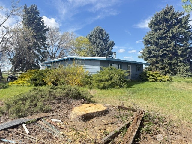 This charming 15.8-acre farm offers a rare opportunity to enjoy peaceful country living with stunning mountain views.  The 4-bedroom rambler was built in 1959 and has great bones, plus two wood-burning fireplaces to keep things cozy. It could use some updating, but it’s a great opportunity to make it your own - ideal for buyers searching for a fixer-upper with land or a country home to renovate.  Nestled on a corner lot surrounded by mature trees, the property provides privacy and a serene setting. The farm is well-equipped with approximately 11 acres in hay production with QCBID water. Outbuildings include a 2,000 sq ft barn, a 1,240 sq ft loafing shed/horse stalls, and an additional 1,800 sq ft shop—ideal for a variety of agricultural, livestock, storage, or workshop needs. To help you get started, the sale includes essential farming equipment: swather, baler, and wheel lines.   Whether you're looking to expand your agricultural pursuits or embrace a quieter rural lifestyle, this property is ready to make your vision a reality.