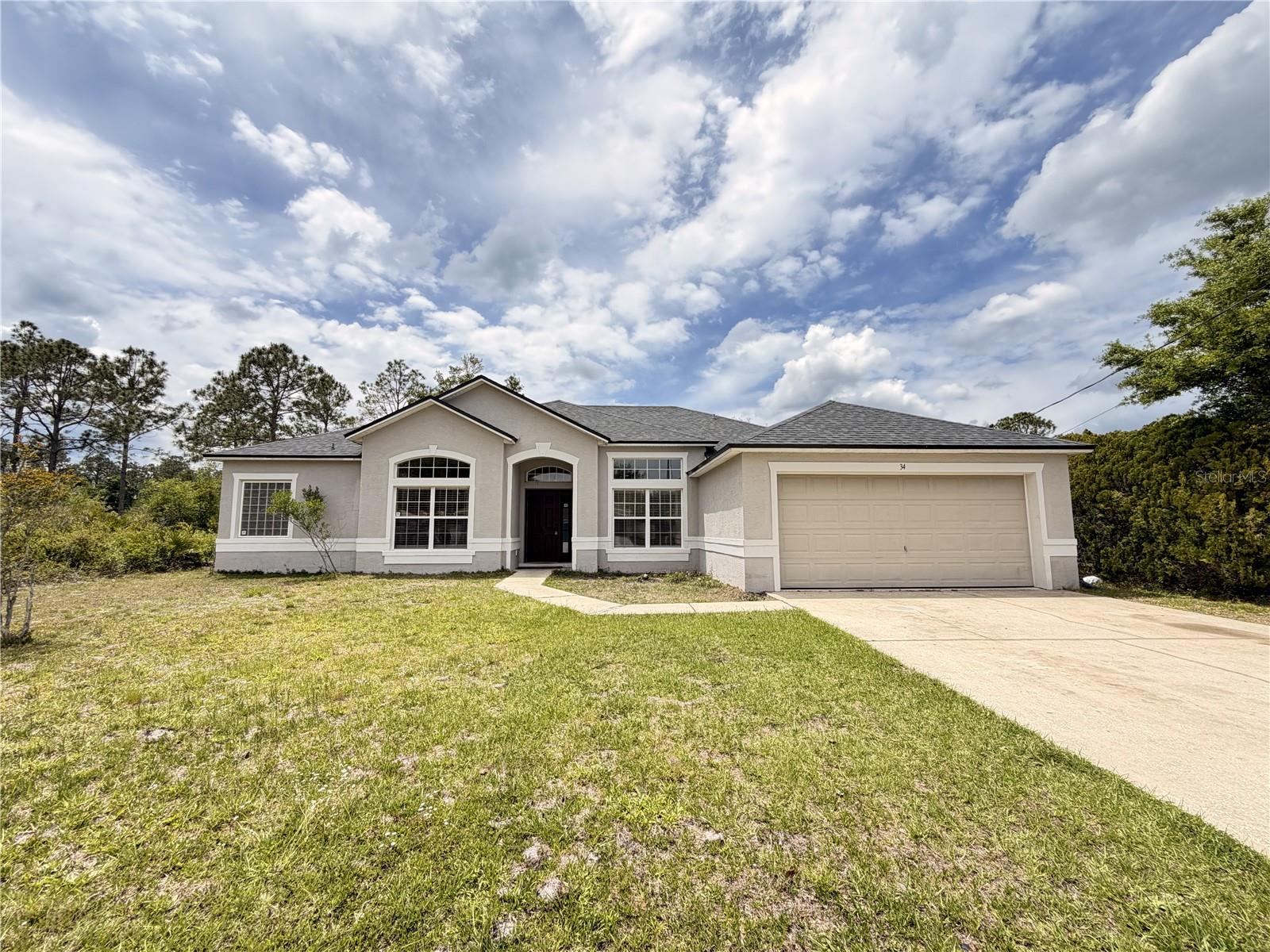Spacious house spanning over 2000 square feet. This home features 3 generously sized bedrooms, 2 full bathrooms, and a 2-car garage equipped with an automatic door opener. The roof was replaced in 2021, providing added peace of mind. The thoughtfully designed split floor plan includes a formal dining area, a cozy family room, and a generously sized living room, perfect for entertaining or enjoying quality family time.  The kitchen boasts a walk-in pantry and ample counter space for preparing delicious meals. The primary bathroom features dual sinks, a garden tub, and a walk-in shower. Split floor plan with generously sized bedrooms throughout.  All areas have ceiling fans. The combination of tile and laminate flooring throughout adds both elegance and durability to the interior. Conveniently located near shopping, schools, and the popular Palm Coast Town Center, this home also provides easy access to nearby beaches, giving you the best of both convenience and coastal living. Whether you're looking for a primary residence or an investment opportunity, this property offers space, value, and location all in one.