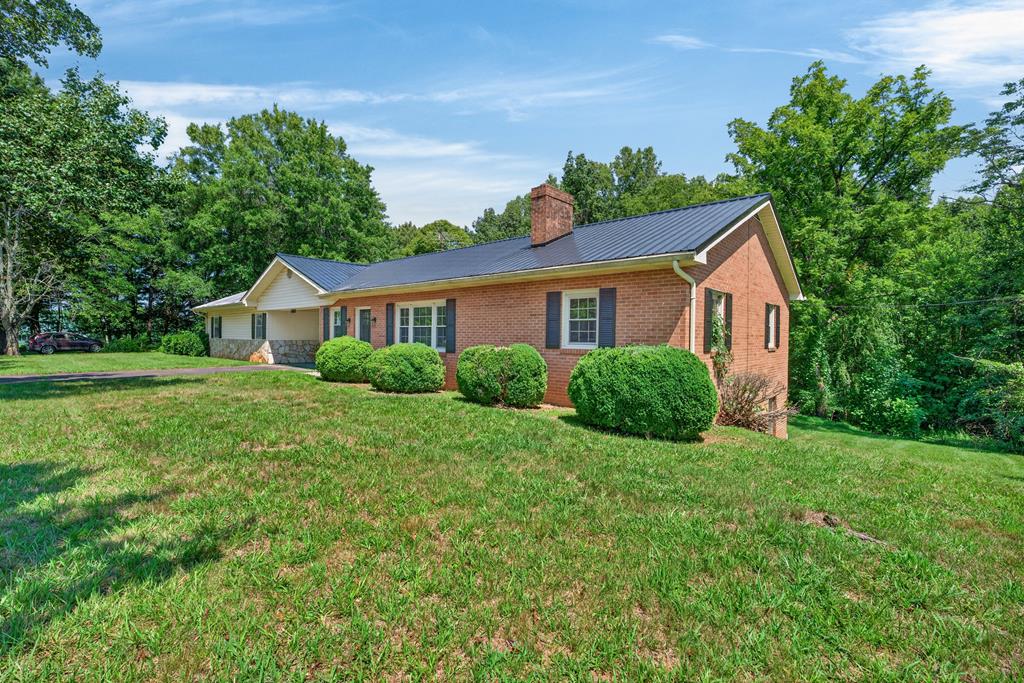 Beautifully maintained brick ranch in Ararat, VA Recently completely remodeled. 3-bedroom, 1-bath, updated with new LVP flooring, fresh paint throughout, new fixtures and lighting. The bathroom features a new toilet, vanity and sink, while the kitchen has new appliances & sink. Additional improvements: New hot water heater, new metal roof, replacement windows, a new front entry door and a spacious back deck. A level front lawn, a large side yard and plenty of outdoor space to enjoy. The full basement provides excellent storage or workshop possibilities and includes the laundry. Car enthusiasts, hobbyists or anyone needing extra storage will appreciate the exceptional 4-car garage capacity, with 2 attached garage spaces and a separate two-car detached garage/shop. Detached garage includes a bathroom & additional building attached at the rear. A paved driveway, private well and septic system complete this well-cared-for country property offering comfortable one-level living, abundant garage space and lots of room.