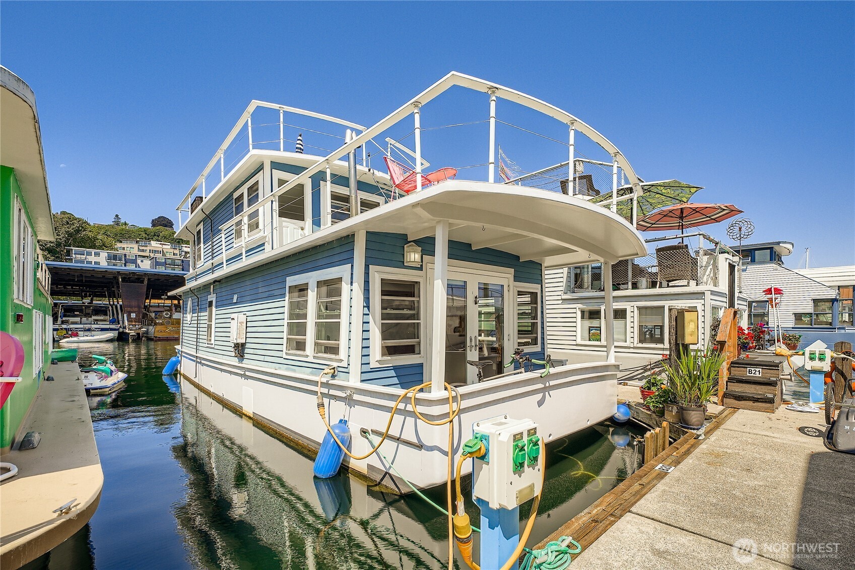Welcome aboard your own waterfront retreat on iconic Lake Union. Perfectly positioned at the end of the dock, this charming Seattle houseboat offers panoramic water views and an unforgettable lifestyle in the heart of the city. Start your mornings with coffee on one of two covered decks, unwind on the expansive rooftop deck, and enjoy front-row seats to spectacular sunrises, Fourth of July fireworks, Duck Dodge races, and the daily parade of seaplanes.  Inside, vaulted ceilings and walls of windows fill the home with natural light, creating an open and inviting atmosphere. The thoughtfully designed layout features a full kitchen with breakfast bar, built-in queen bed, full bath, convenient washer/dryer combo, and an upper-level bonus room with a built-in bar—ideal as a guest space, entertaining area, or inspiring home office.  The monthly slip lease of $1,598 includes moorage, insurance, DNR fees, facility fees, liveaboard status, & Property Data Protection. Launch your paddleboard or kayak right from your dock and embrace the best of Seattle's floating home lifestyle. Financing available. Pet and rental friendly. Just minutes from Amazon, Google, Adobe, and everything South Lake Union has to offer.