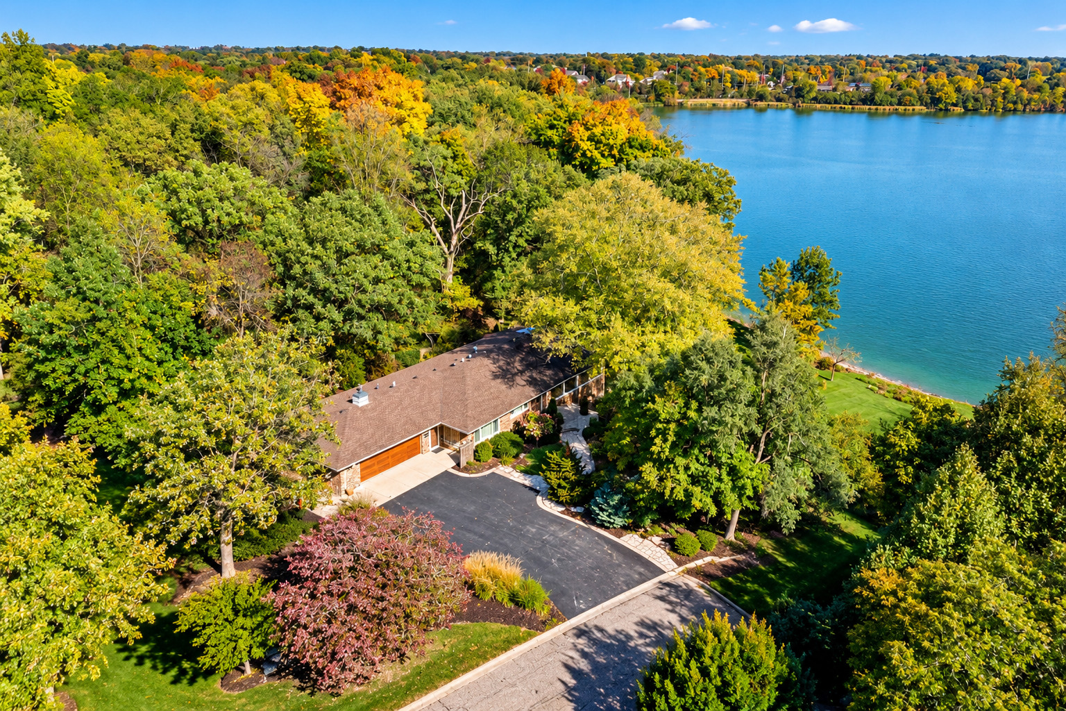 Spectacular waterfront ranch overlooking beautiful Baker's Lake near downtown Barrington! Discover an extraordinary combination of comfortable luxury, natural beauty, privacy, and waterfront living in this beautifully maintained 3-bedroom, 2.5-bath ranch home with a fully finished walkout lower level. Nestled on a magnificent, professionally landscaped property overlooking picturesque Baker's Lake. Enjoy breathtaking water views, an expansive manicured lawn, mature trees, and a peaceful setting all within a short walk to downtown Barrington! You'll appreciate the home's impressive curb appeal, attractive brick exterior, beautifully designed landscaping, and welcoming entrance. Discover bright, spacious living areas with gorgeous hardwood floors, recessed lighting, and an incredible wall of windows that showcase panoramic views of the lake and the surrounding landscape. The spectacular living room features an expansive layout, a fireplace, and an abundance of natural light. The adjoining dining area offers beautiful water views and an inviting atmosphere for hosting family and friends. The kitchen features rich wood cabinetry, generous counter space, and a large center island with a newly installed high-end range and hood. It includes breakfast bar seating, stylish pendant lighting, and a convenient adjoining eating area. Large, newer windows throughout the main living spaces bring the outdoors in and offer stunning views in every season. The main-level primary bedroom offers a peaceful retreat complete with a cozy fireplace, a huge closet and dressing area, brand-new carpeting, fresh paint, and decorative accessories. The fully finished walkout lower level, with newly installed luxury vinyl tile, dramatically expands the home's living space and adds two additional bedrooms with new carpeting and a full bathroom, offering comfortable accommodations for family and guests.  Step outside and experience what makes this property truly extraordinary! Enjoy your own private waterfront paradise featuring an expansive, gently sloping lawn, spectacular mature trees, colorful perennial gardens, winding stone pathways, and meticulously maintained landscaping. Relax on the spacious outdoor deck, entertain guests on the beautiful stone patio with a fire pit, or unwind beside the tranquil koi pond surrounded by lush landscaping. The expansive grounds offer a spectacular setting for outdoor entertainment, recreation, or simply enjoying nature's serenity. Additional highlights include a heated 2.5-car garage with attractive epoxy flooring, a generous driveway, and a beautifully landscaped approach. Best of all, this peaceful waterfront setting is just a short walk from the heart of downtown Barrington, with its wonderful restaurants, shopping, entertainment, and Metra train service. A rare opportunity to enjoy breathtaking views of Baker's Lake, spectacular grounds, exceptional indoor and outdoor living spaces, and the convenience of downtown Barrington just moments away. Truly a one-of-a-kind property offering the very best of Barrington living!