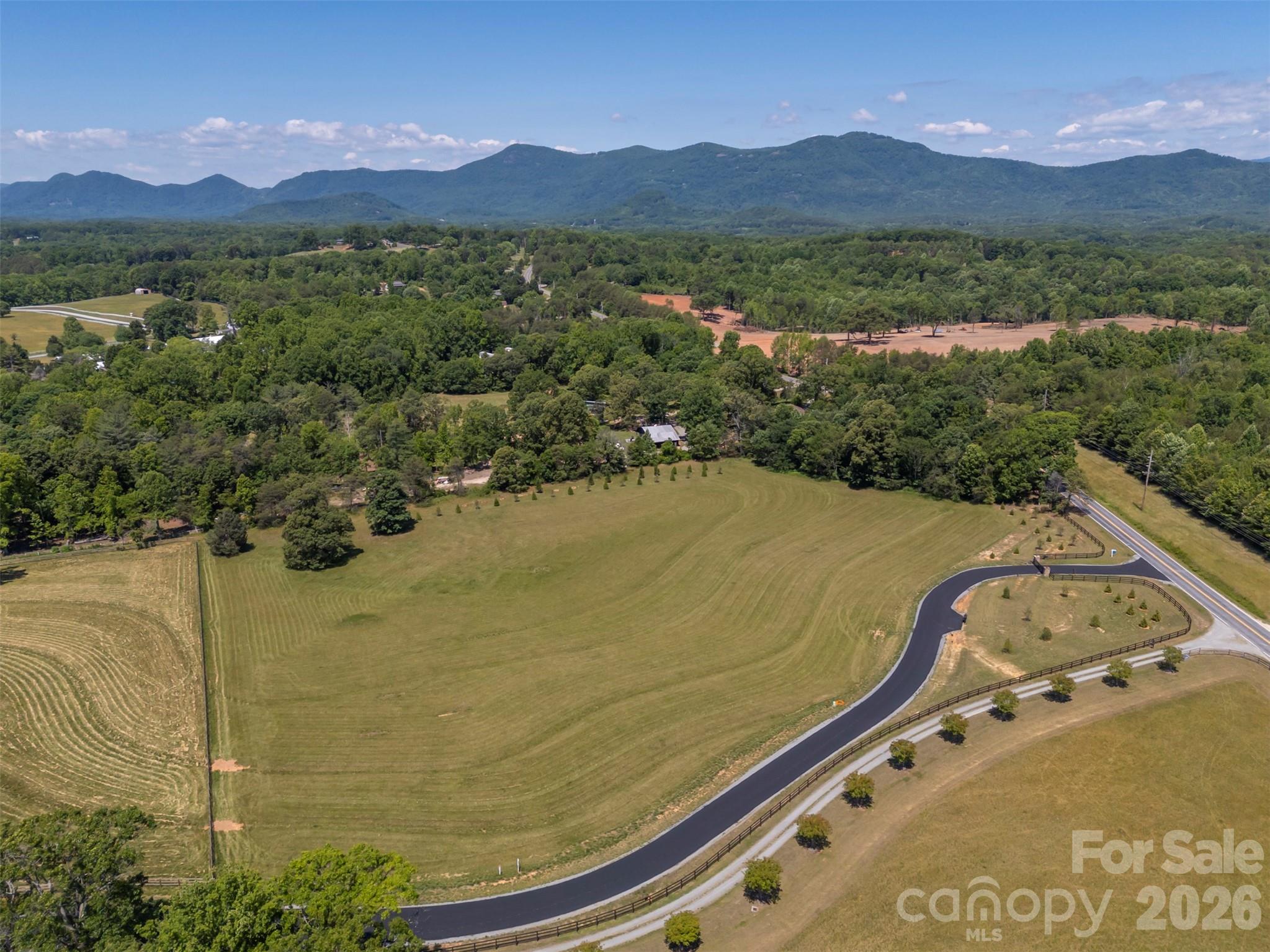 Mountain Views! Mountain Meadows is a newly created gated community in the heart of Tryon Horse Country with nearby FETA trails. It is designed for equestrians but equally suited for anyone who wants some elbow room. Lot 1, with a big mountain view, is 10.97 acres of gently sloping grassland and a corner of shade trees for horses. There are only seven lots in total, each roughly 10 acres, with about 2 miles of walking and riding trails within the development. It is handsomely gated to minimize traffic and enhance security. The road will soon be paved, and all utilities will be underground. Internet speed of 100 Mbps makes working from home a breeze. You can have a few chickens, too! The town of Columbus and access to I-26 is only an 8-minute drive, with restaurants, a grocery store, and a hospital.