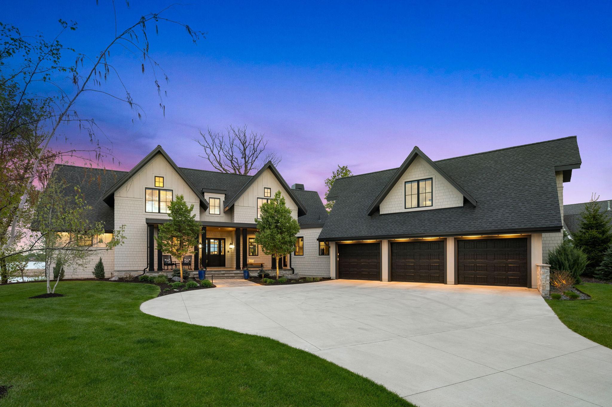 Welcome to this absolutely stunning 5-bedroom, 4-bathroom custom-built home, thoughtfully crafted in 2019 by Denali Custom Homes in collaboration with Alexander Design Group, and nestled in the highly sought-after The Cove on Lake Minnetonka community in Minnetrista.Uniquely designed with an exceptional layout, beautiful craftsmanship, and delightful surprises throughout, this home blends style, comfort, and functionality at every turn. This exceptional property includes two private permanent boat slips on Lake Minnetonka and access to outstanding HOA amenities, including two pools, pickleball courts, and two full clubhouses available to reserve for gatherings and events. Enjoy direct access to the Minnetonka Regional Trails and convenient proximity to the Dakota Rail Trail, Carver Park Reserve Trail along with nearby shopping, dining, and entertainment. From the welcoming front porch, white oak floors lead into a light-filled main level with soaring 12-foot ceilings and walls of glass framing breathtaking backyard and Lake Minnetonka views. The entire home is also thoughtfully wired with a surround sound speaker system, enhancing both everyday living and entertaining throughout. The chef’s kitchen features quartz countertops, a large island, custom cabinetry, premium Thermador appliances, a Scotsman ice maker, built-in coffee system, and an impressive walk-in pantry. The kitchen flows into the dining and living areas, where expansive Marvin windows, a gas fireplace with shiplap surround, and built-ins create a warm yet dramatic gathering space. A sunroom with wood-burning fireplace opens to the maintenance-free deck, while the serene primary suite offers lake views, a fireplace, heated bath floors, spa-like shower, and a custom walk-in closet. The main level also includes a thoughtfully designed mudroom, laundry, and access to the heated, insulated three-car garage with floor drains. Upstairs, two separate wings offer exceptional flexibility, including a bonus room above the garage with its own mini-split system and plumbing rough-in, a dedicated office with vaulted ceilings and built-ins, and a unique bedroom featuring a loft and hidden secret room. The walkout lower level is built for entertaining with a spacious family room, fireplace, wet bar, recreation room, and three additional bedrooms.Outdoors, enjoy a beautifully landscaped yard with a paver patio, firepit area, deck, irrigation system, invisible fence, and a path leading to two private permanent boat slips—all set against stunning Lake Minnetonka views. This one-of-a-kind home blends luxury, comfort, and exceptional lake living.