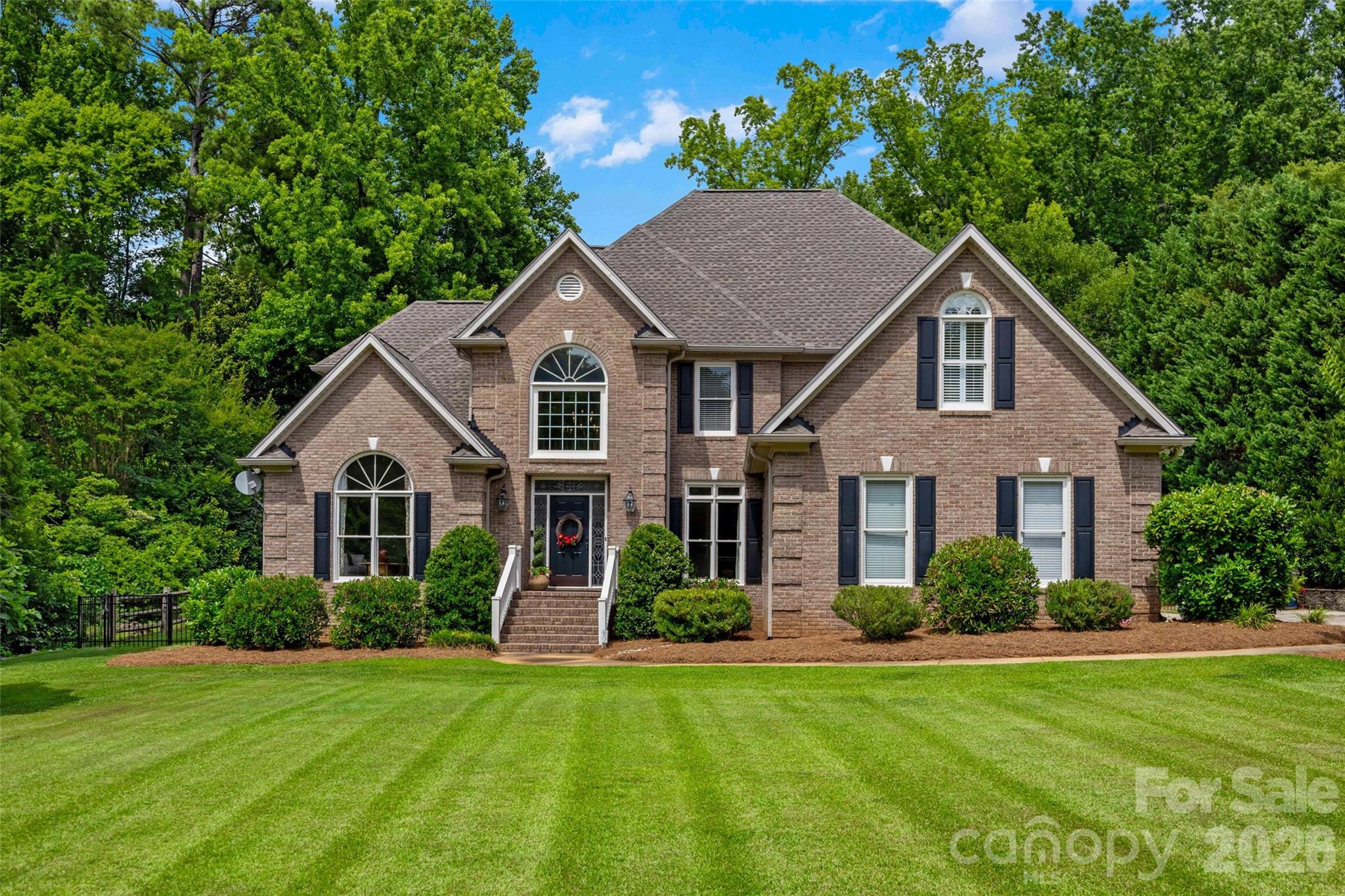 Welcome to a home designed for effortless daily living and spectacular entertaining. From the moment you step into the soaring entrance foyer with its custom built-in wine and display shelving, the thoughtful layout unfolds. The main level offers a quiet home office, a formal dining room, a comfortable living room anchored by a fireplace, and a spacious primary suite featuring a walk-in closet, dual sinks, a separate shower, and a relaxing whirlpool tub. The kitchen is a true centerpiece, featuring a large central island, a classic farm sink, a gas cooktop with a convenient pot filler, a sleek built-in refrigerator, and a premium Viking Professional double wall oven. The upper oven features side-swing French doors that open simultaneously with a single pull, making it safer and easier to access heavy dishes. Right nearby, an under-stairs alcove functions as a dedicated coffee bar, while the highly organized laundry room includes a built-in sink and an extra beverage fridge. Dual staircases lead you to the upper level, where a flexible rec room offers plenty of space for games, media, or homework. For practical utility, both the attached two-car garage and the backyard shed are wired with 220-volt power, making it simple to set up a workshop or add an electric vehicle charging station. Outdoor living centers around a screened porch with adjustable EZ Breeze windows that slide down easily to control the airflow. The porch steps out onto a large deck and an inground pool with a surrounding concrete patio. The fully fenced backyard has a peaceful, wooded backdrop for added privacy. The detached shed is fully heated and cooled, currently utilized as a pottery studio but versatile enough for any workshop or home hobby. Located in Meadow Lakes II, the community offers a walking trail to assigned middle and high schools, the clubhouse, pool, ponds, and tennis courts.
