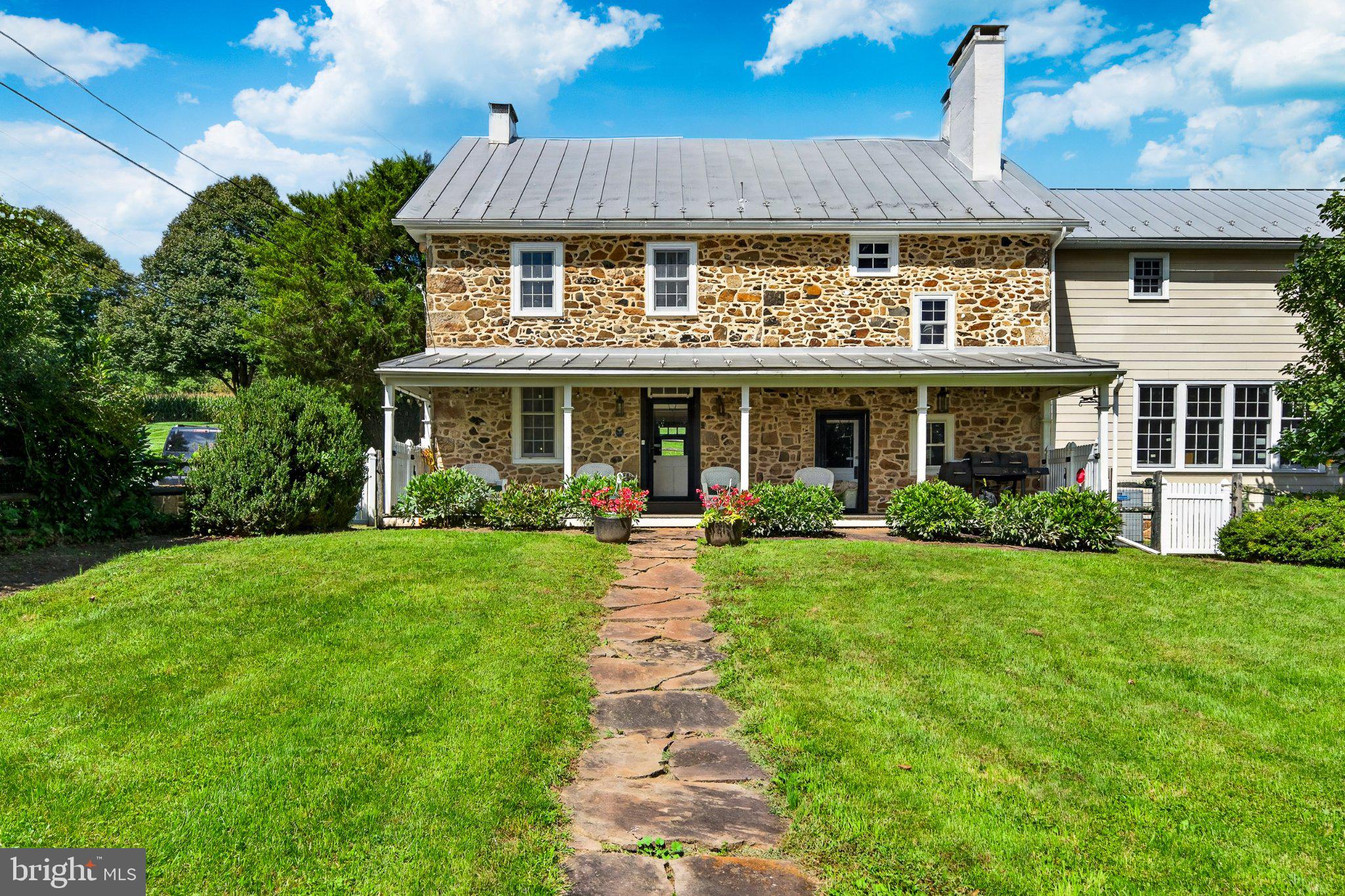 Step into centuries of history at this classic Pennsylvania farmhouse, circa 1809, with two thoughtful additions completed in the early 1900s. Set on 4.2 private acres in the East Nantmeal Village Historic District and listed on the National Register of Historic Places, this home was lovingly restored  21 years ago — new windows, plumbing, and electric throughout — while preserving the soul of the original structure. Layers of old horsehair plaster were painstakingly removed to reveal the stunning original stone walls found throughout the home's interior, while the exterior stone was cleaned and repointed.Wide-plank, random-width, re-claimed heart pine flooring runs through most of the house. The heart of this home is its stunning gourmet kitchen — part of a bright, beautifully finished addition (approx. 12 years old) — featuring a large center island topped in granite, a farmhouse apron sink, and a suite of stainless steel appliances. Custom glass-front cabinetry, antique-style iron lantern pendant lighting, and white pine flooring blend seamlessly with the home's historic character, while French doors off the kitchen open to a covered porch for effortless indoor-outdoor entertaining. Above the kitchen, a massive room with soaring vaulted ceilings and exposed wood beams — currently used as an office — offers exciting flexibility — envision a primary suite, additional flex space, or a private retreat. The original walk-in fireplace in the keeping room, along with the dining room fireplace, have both been relined and are in full working order, offering warmth and ambiance on cold winter nights. The great room's dramatic exposed stone accent wall is anchored by a propane gas stove, creating a stunning focal point that opens seamlessly to the kitchen.The thoughtful floor plan includes a beautifully designed, accessible full bath off the kitchen and a convenient half bath near the stairs in the keeping room on the first floor, plus a full bath upstairs. Upstairs and on the third floor, charming original bedrooms offer character and flexibility, including potential for multi-generational or dual-family living.Outside, enjoy two covered sitting porches, a storybook Japanese Magnolia tree,Crepe Myrtle trees,  established peony gardens, and direct access to scenic bridle trails winding through the property and neighboring land. Equestrian and hobby-farm buyers will appreciate the four-car garage/barn with two horse stalls above and two below, open pastures (currently grandfathered for 3–4 horses),. A separate stone cabin on the property — the oldest structure on site, dating to circa 1735, with a dramatic walk-in fireplace — offers exciting potential as a wine cellar or outdoor entertaining space for the right buyer.Only four families have called this property home since William Penn himself first conveyed the land — a rare continuity of stewardship that speaks to just how special this place is. This is a rare opportunity to own a piece of history — meticulously maintained, thoughtfully updated, and full of character that simply cannot be replicated today.Open House to start showings 9/17/26  4-7pm