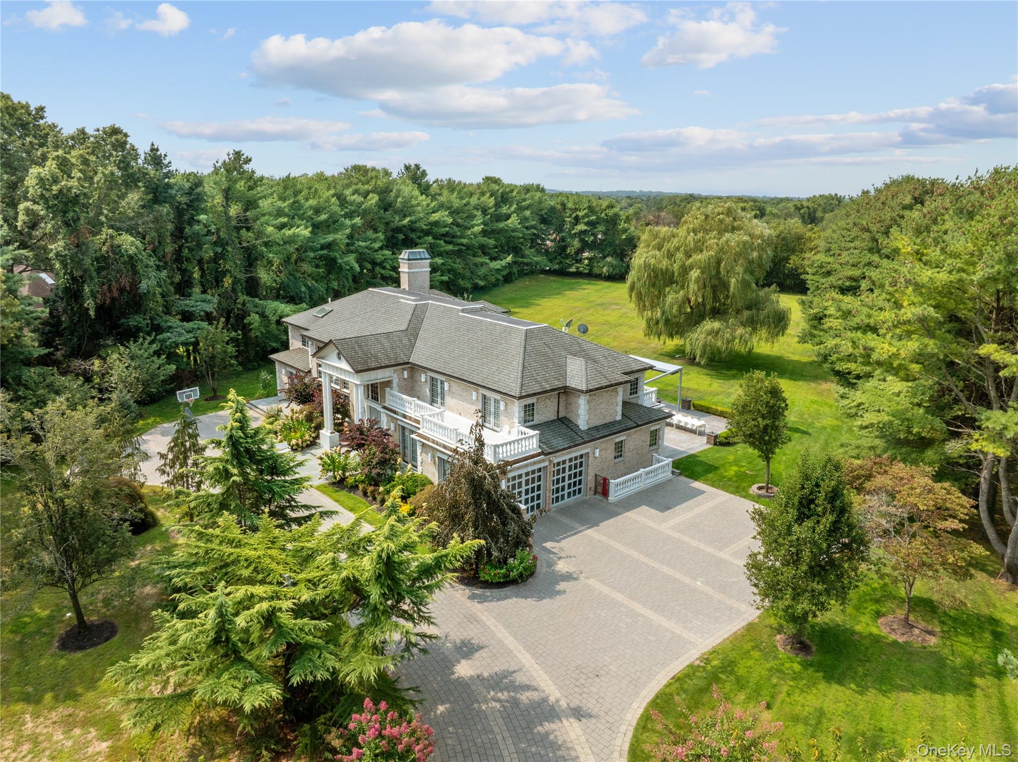 This gorgeous Brick Colonial, located in Upper Brookville, is a beautiful and elegant estate that sits on 2.53 acres. Built in 2007, this residence offers an impressive 6 bedrooms and 7 bathrooms within its expansive 6,921 square feet of living space.

Step inside to find a home designed for both grand entertaining and comfortable living. The first floor features a formal living room, a formal dining room, and an eat-in chef's kitchen with a breakfast bar and a large island. This level also includes a den with a fireplace and a dedicated bedroom or office with a full bath. Luxury amenities abound, including a media room and a stunning indoor pool, perfect for year-round enjoyment. For convenience, the home is equipped with a central vacuum, heated floors, and an elevator.

The second floor is home to five bedrooms, including a private and serene primary ensuite bedroom with a balcony and a jacuzzi. There is also a junior primary ensuite with its own balcony, as well as three additional bedrooms and two full bathrooms with front balcony

The full, finished basement offers even more living space, with two bedrooms, a full bath, and a laundry area, plus outside access.

Outside, the property features a patio, porch, and a 2-car garage. This home is part of an association with an annual fee which covers common area maintenance. 5 Farmwoods Lane seamlessly blends classic Colonial architecture with modern luxury, creating a truly exceptional living experience.