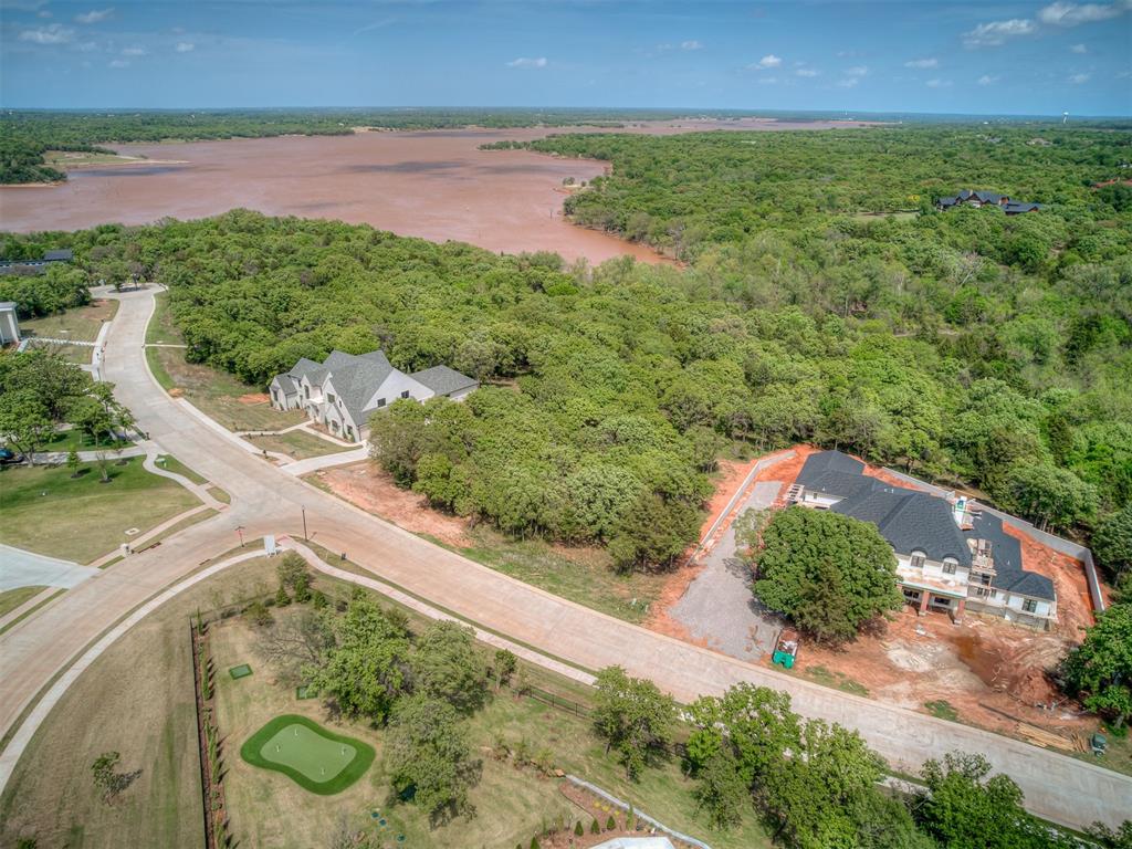 Welcome to Shoreline Addition in East Edmond—one of Arcadia’s newer gated communities on the south side of Lake Arcadia. This 1.17-acre homesite sits among just 21 wooded lots, offering a quiet, tucked-away feel while still being close to everything. The lot features mature trees with underbrush already cleared, giving you a great starting point to design and build. With a 3,500 square foot minimum, the neighborhood is tailored for larger, custom homes, with surrounding properties ranging up to 9,000 square feet. One of the standout features—this lot backs to Army Corps of Engineers land, so you’ll have that extra layer of privacy and no rear neighbors. It’s the kind of setting that feels secluded without being far out. Location-wise, you’re about 15 minutes to downtown Oklahoma City, under 10 minutes to the lake, and just a few minutes to I-35 for an easy commute. If you’ve been looking for a place to build with space, privacy, and a little bit of nature around you—this one checks all the boxes!