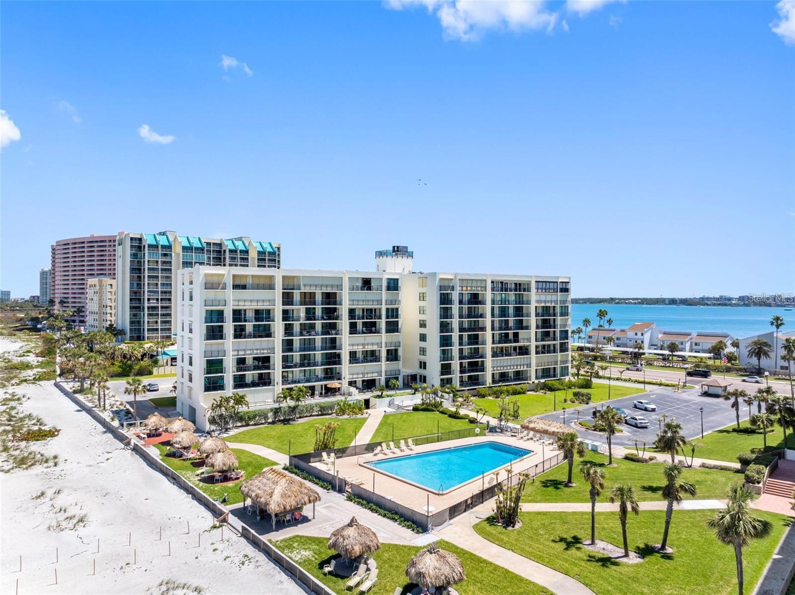 An ideal oceanfront location and carefree Florida beach lifestyle pair beautifully in this special Sand Key property. Updated and move-in ready, this elevated first floor corner unit offers a perfect blend of convenience and easy access to the pool and one of the most pristine beaches that you will find anywhere. The floor plan is open and features luxury vinyl plank flooring that runs throughout, open kitchen, upgraded sliding doors that access a spacious balcony overlooking the pool and beach, and a large, West facing window that fills the space with natural light and also provides great views of the beach and Gulf. All windows and doors are protected by hurricane shutters. Both bedrooms are spacious with plenty of room for king sized beds and the owner's suite features an e-suite bath and dual closets. Impeccably maintained, this unit is freshly painted and the AC was replaced in 2025. A new water heater was added in 2022. This property also comes with a covered parking space and storage locker for your beach toys! Whether you are looking for a full-time beach home, vacation getaway, or investment opportunity, this property checks all of the boxes. South Beach I is a premiere gated community that offers lush tropical landscaping and a tranquil, welcoming atmosphere. Experience captivating sunsets from the tiki huts and enjoy effortless access to the solar heated resort-style pool that overlooks the Gulf. Other amenities include a club room for social gatherings, pool baths, fitness room, paddle board storage, and onsite manager. Close to wonderful shops, restaurants, entertainment, and the Jolley Trolley! Call now to schedule your tour. Virtual tours are also available.