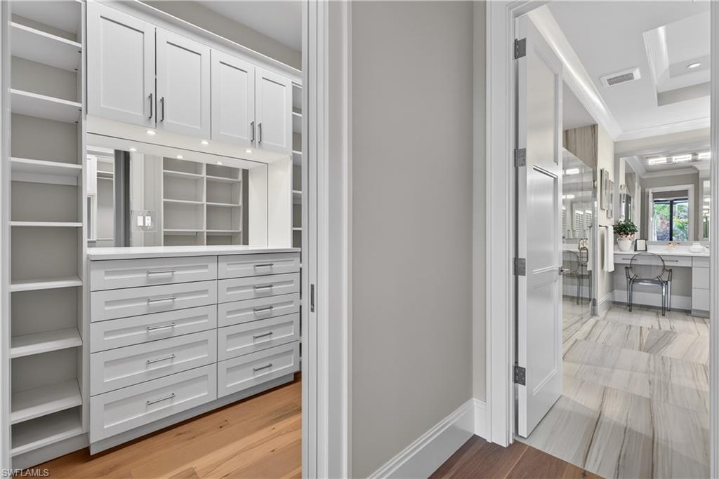 Walk in closet with light wood-style floors