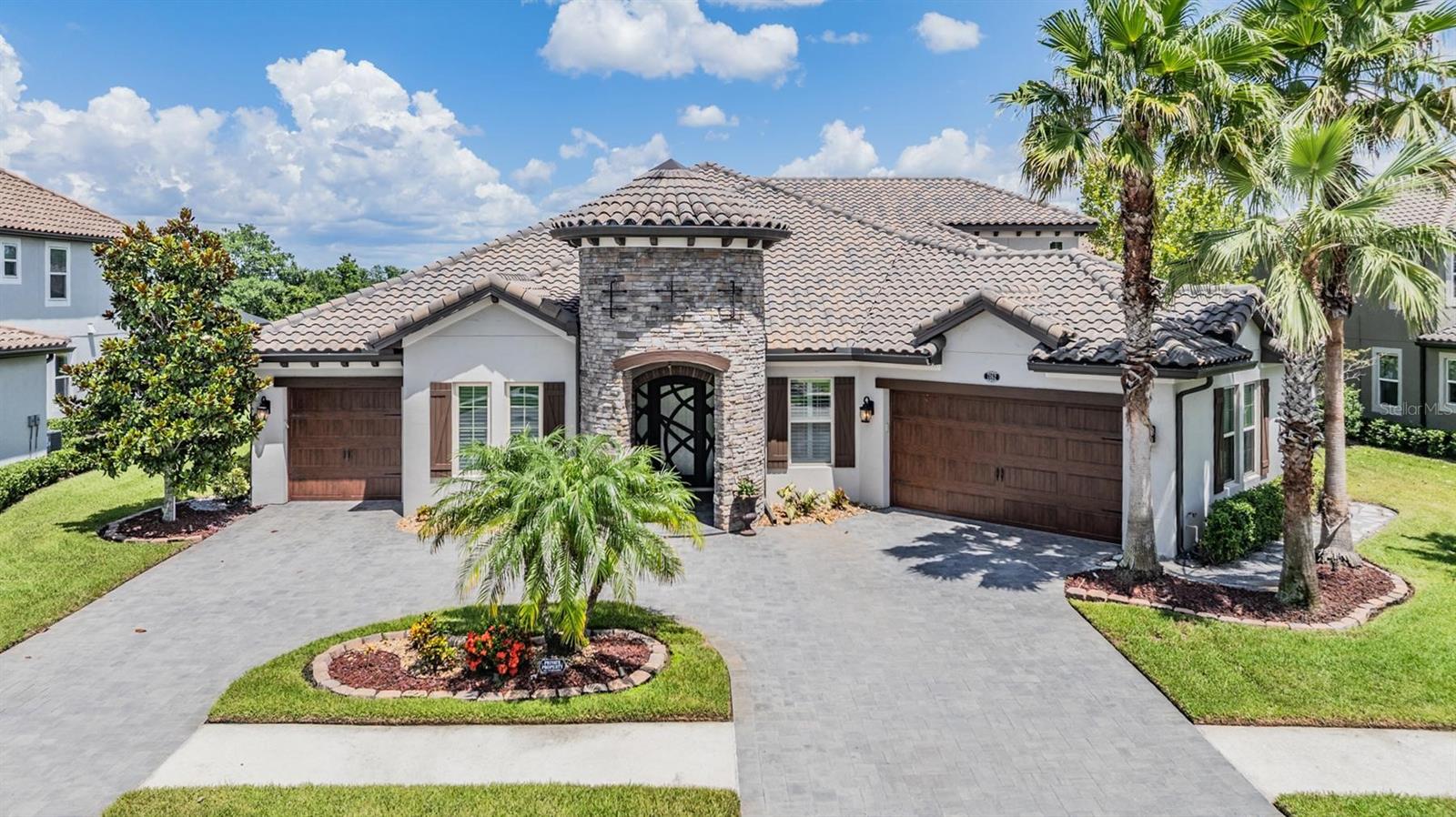 ONE OF A KIND CUSTOM BUILT ESTATE HOME! Must see to believe this HIGHLY UPGRADED home. You'll love this stunning property from the minute you drive through the gates and pull up to the pavered circle drive with lush tropical landscaping. You'll feel like royalty as you approach the castle like front porch, you'll also notice the exquisite custom built iron door. Once inside, things just keep getting better and better! The attention to detail is superior...check out the wood beams, gorgeous lighted tray ceilings and heavy crown molding. The custom barn door that adds privacy to your home office/den is flanked by wood shutters, tile flooring and fabulous lighted tray ceilings. Continue on and you will see the spacious dining room that will hold even the largest table for a huge gathering with ease, including the added built-in wine bar with glass door, cabinets and wine fridge will allow you to entertain in style. The spacious family room boasts lighted double tray ceilings and is open to the the dreamy kitchen including Viking appliances including 5 burner gas cooktop, pot filler, double ovens, microwave drawer, hood vent, under cabinet lighting and abundant cabinetry plus huge extra storage under the extra large center island. Walk-in pantry with custom cabinetry and automatic lighting. The owners suite is over the top incredible, TWO HUGE BUILT-IN CUSTOM CLOSETS with automatic lights, lighted trayed ceilings, wood tile flooring, dual switched reading lights, and fabulous ensuite bath! Custom bathroom door leads to a walk-in shower with overhead rain shower, multiple shower heads with body jets and a bench seat inside shower! European soaking tub, dual sinks, abundant cabinetry, and private water closet. The secondary bedrooms are also on the first floor with a split arrangement for privacy. Bedroom 2 & 4 also have ensuite bathrooms included and all the closets are spacious. This is a one story home with a large bonus upstairs including a full bath, walk-in media closet and french doors to a covered & caged balcony with a spiral staircase down to the lower covered & screened in lanai. Enjoy relaxing in your new Florida retreat in your pool/spa which is heated and jetted for total relaxation. Gorgeous travertine flooring on the extra large screened lanai area with plenty of room for entertaining and grilling in your outdoor kitchen with space for food prep or eating. Watch the wildlife in the pond and conservation as you enjoy your morning coffee or unwind at night with a glass of wine. Relax in this stunning home that has it all! Neighborhood features: Resort Style Zero Entry Pool & Splash Zone, 6 Ln Jr Olympic Pool, & pool by Pavilion. Fitness Center, Club House, Tennis & Basketball Courts, Large & Small Dog Park, Splash Court, 2 Large Parks with playground plus, Private Sports Courts with Playground & basketball Court in each village. Excellent location with a new Publix, Florida Medical Clinic, a new Daycare, Starbucks Circle K, Chick-fil-A and more coming just outside the entrance to the neighborhood. Close to Great Schools, Community College, Hospitals, Wire Grass Mall, Tampa Premium Outlet Mall, Ice Rink, Sams Club, Costco, Movie Theater, and lots of Dining. Easy access to I75, 275, Tampa Interational Airport and Downtown Tampa. CDD is already included in tax amount.