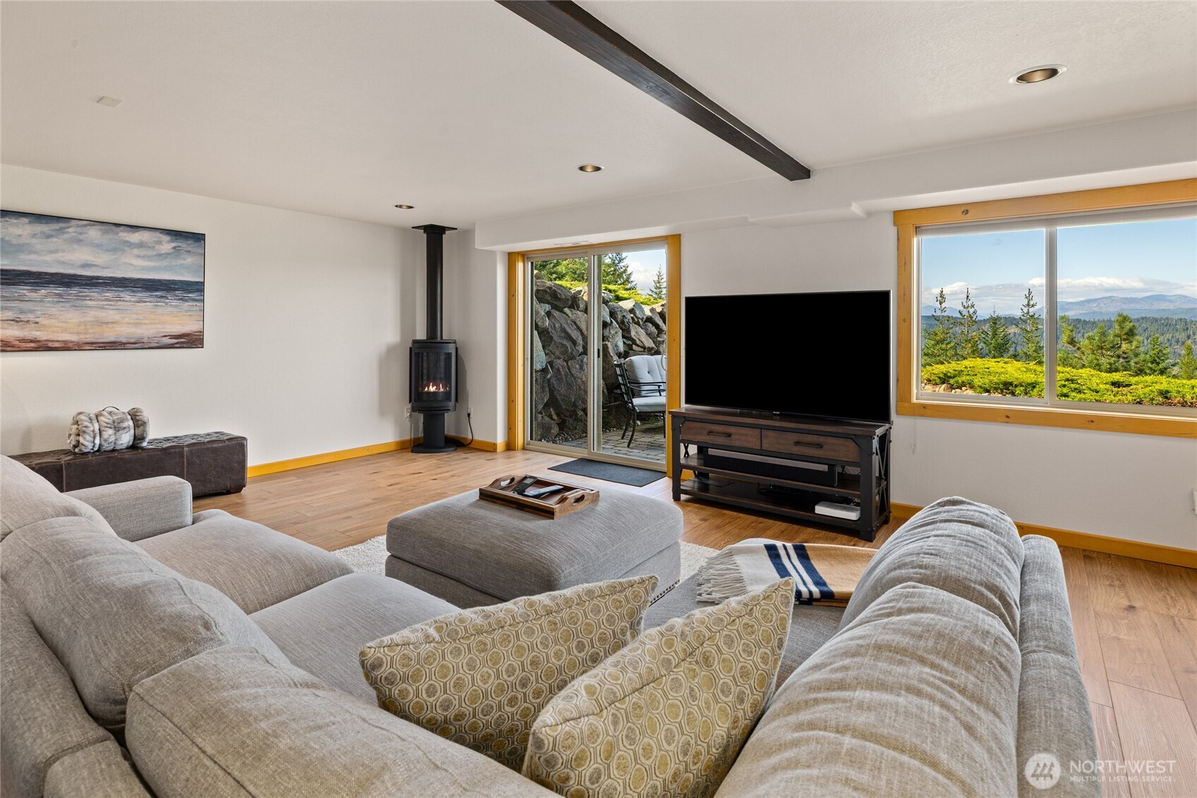 Lower-level living area framed by large windows showcasing the surrounding mountain landscape.