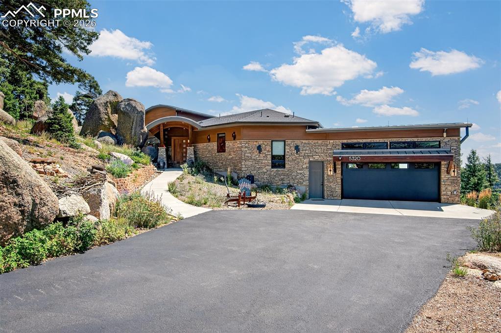 Welcome to "Falling Rock," a spectacular custom mountain home designed by the well-respected, local Parade of Homes architectural firm, LGA Studios and build by Palace Homes! Seated on an irreplaceable, one-of-a-kind lot, the home was designed to seamlessly fit amongst massive boulders with open sky views of Colorado Springs and beyond. Adjacent to the property are two Crystal Park historical landmarks, including one with an official plaque. Showing like new and meticulously maintained, this immaculate residence is move-in ready. Inside, a large boulder serves as a centerpiece in the open-concept living area, perfectly bringing the outdoors in. The gourmet kitchen features "caressed" granite, a sandstone sink, and high-end custom appliances and cabinetry. The grand living room boasts a wood-burning fireplace and glass pocket sliding doors opening to a large back deck with breathtaking views from all directions! Above, a loft office is perched perfectly via an elegant spiral staircase. The primary suite is fit for royalty, offering a 5-piece en suite with a steam shower, soaking tub, heated tile floors, and a walk-in closet connected to one of two laundry rooms. The layout includes three additional spacious bedrooms (one currently used as an office) and two more bathrooms. Complete with an oversized 2-car garage and a dedicated ATV garage, this home is the perfect vacation retreat or year-round sanctuary. Situated on an irreplaceable, one of a kind lot the home is perfectly surrounded by majestic rock outcroppings and even features a custom chairlift seat from Angel Fire Resort on the patio… This is mountain living redefined!