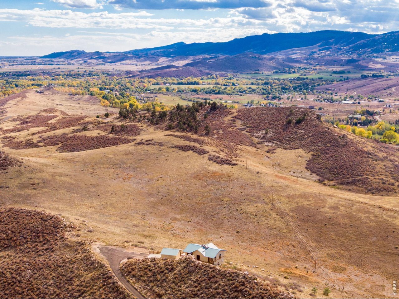 Discover the freedom of Colorado acreage living on 15 private acres with sweeping 360-degree views of the foothills, sparkling city lights, and unforgettable sunrises and sunsets. Gated, secluded, and perched atop a ridge, this rare LaPorte retreat offers no HOA, open zoning, and room for horses, animals, boats, RVs, and all your toys-just 15 minutes from Old Town Fort Collins. Tucked against a dramatic rock outcropping with a tranquil water feature, the home blends indoor and outdoor living with exceptional privacy and natural beauty. An expansive, refinished wraparound deck provides the perfect place to entertain, unwind in the hot tub, or enjoy abundant wildlife and panoramic views. Inside, vaulted ceilings, expansive windows, and an open floor plan fill the home with natural light. Distinctive features include refinished hardwood floors, a sunken living room with stone flooring, and a two-sided freestanding wood-burning fireplace. The spacious kitchen offers a butcher-block island and plenty of room to gather. The oversized main-floor primary suite features direct deck access and stunning views. The lower level adds two bedrooms, a full bathroom, a flexible office or bonus room, a separate exterior entrance, and a second cozy wood-burning fireplace. A large detached two-car garage provides additional storage and workspace. Enjoy the privacy, space, and versatility of acreage living without sacrificing convenience-just 10 minutes to LaPorte and approximately 15 minutes to Old Town Fort Collins for shopping, dining, schools, and everyday essentials. If you're looking for Colorado acreage, panoramic mountain views, room to roam, and the freedom to live your way, this exceptional property delivers.