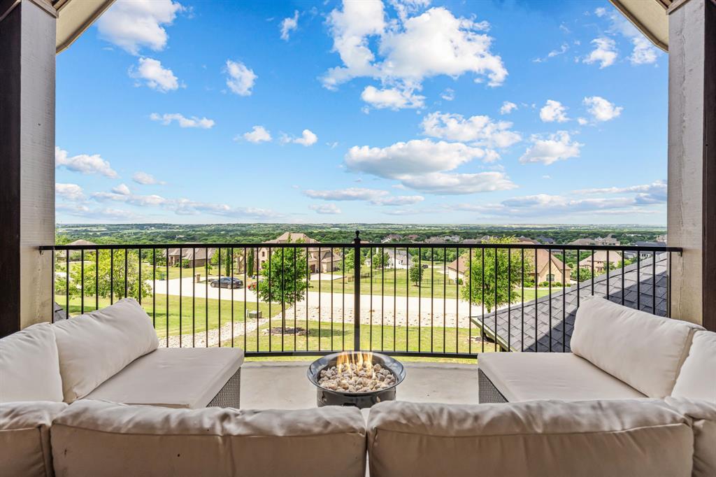 Perched high above the surrounding landscape, this one-of-a-kind custom home captures breathtaking panoramic views from one of the most scenic hilltop settings in the guarded and gated Bella Flora community in Aledo ISD—truly reminiscent of Texas Hill Country living. From sunrise to sunset, enjoy miles of uninterrupted skyline and an elevated vantage point that makes this property exceptionally rare.Thoughtfully designed for both everyday living and entertaining, the first floor features a spacious primary suite, private guest bedroom, dedicated office, formal dining room, and an open-concept kitchen, breakfast area, and living room—all positioned to maximize natural light and showcase the incredible views. A dry bar and butler’s pantry with a mini refrigerator seamlessly connect the dining room and kitchen, adding both functionality and effortless flow for entertaining.Upstairs offers two additional bedrooms connected by a Jack-and-Jill bath, a media room, half bath, and a versatile loft-style living area with glass doors opening to a west-facing balcony where you’ll experience unforgettable Texas sunsets and sweeping views for miles.Designed as a private outdoor retreat, the backyard features a sparkling pool with tanning ledge and bubblers, attached spa, stone waterfall, covered patio with fireplace, and a detached pergola with built-in grill—creating multiple spaces to relax, unwind, or entertain beneath the expansive Texas sky.Additional interior highlights include hardwood, tile, and carpet flooring, plantation shutters, Cat5 wiring, three zoned HVAC systems, two tankless water heaters, a water storage tank, and two separate garages accommodating up to four vehicles. A new high-impact roof and gutters were installed in May 2025.A rare opportunity to own a true hilltop property with unmatched views in Bella Flora.
