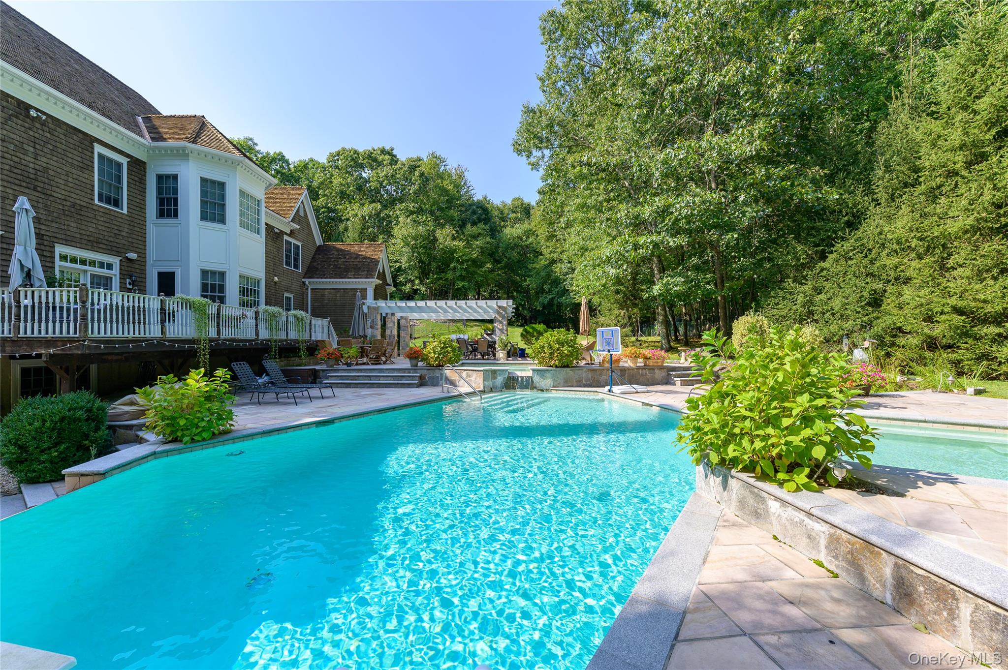 Stately Shingle Colonial. Impressive and beautifully finished interior with high ceilings, beautiful hardwoods, substantial moldings and two fireplaces. Two-Story Entrance Hall. Formal Living and Dining Rooms for elegant entertaining. Chef’s Kitchen with center island and breakfast area open to spacious Family Room. Library/Office perfect for working remotely. Private Primary Suite with two Walk-in Closets and spacious Bath. Four additional Bedrooms plus Second Floor Bonus Room. Lower Level Recreation Room and Gym offers an additional 2200+ square feet. Large deck overlooking the striking pool with two waterfalls, kiddie pool and spa. Summer Kitchen with built-in barbecue, fireplace and dining terrace for an ideal outdoor lifestyle. Five private, fenced acres at the end of a quiet cul-de-sac next to the protected Zofnass Preserve. Gorgeous gardens, large expanse of lawn and scenic woodlands. A spectacular offering!