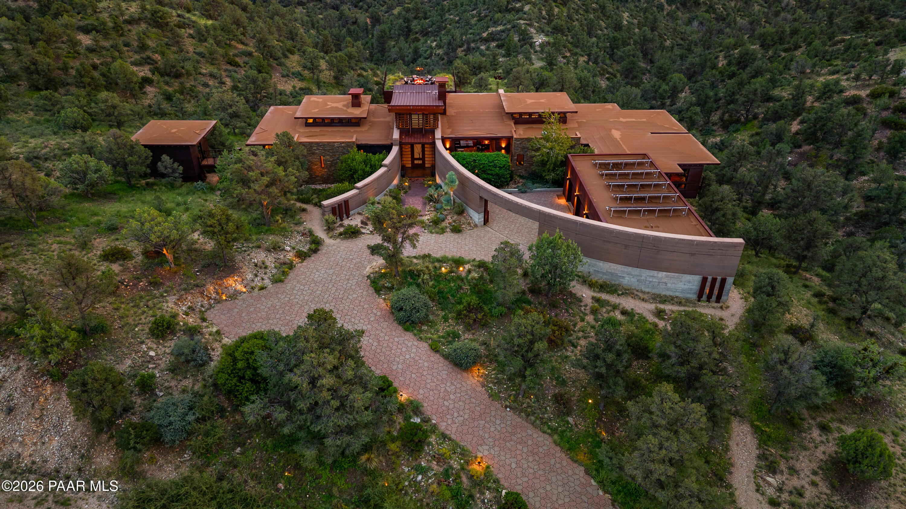 Welcome to a sophisticated masterpiece in the high desert of Prescott. Swaback Architects, Kitchell Custom Builders and Anita Lang IMI Design Studio collaborated to plan, build and design this spectacular property. It took 3 years to complete this gracious and grand home of 6392 SF that brings the elements of nature outside and the beauty of interior architecture together. The home's form maximizes the simplicity of steel, glass, wood, concrete and rammed earth construction producing well-proportioned and comfortable living spaces. The element of nature is outside in the not perfect looking textures of the concrete wall structure then you walk into the interior which is 'art' by itself with each different wall texture.  The exterior walls of rammed earth were constructed by hand-tamping a mixture of aggregate materials between forms to create a colorful striation. Exactly the material used in the buildings of historic ranches in Arizona and New Mexico. This produced the curvilinear nature to the front of the home bringing an organic texture of art in of itself. As you go through the home, you are always walking toward a point of beauty.  Every room has an un obstructed view of Granite Mountain and national forest land. A home full of rich textures , inside and out!