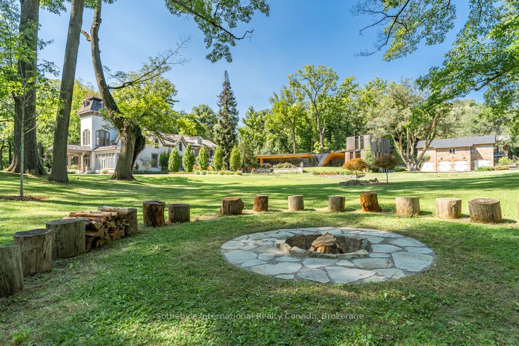 Nestled where history gracefully intertwines with modern elegance, this exceptional estate invites you to experience unparalleled luxury. Set against ancient trees & expansive views at nearly 3,000 feet on the escarpment, this property transcends mere residence- it is a sanctuary. Spanning three separately deeded parcels, the estate features four exquisite detached residences, a state-of-the-art spa & pool house by Partisans, a historic barn, a four-car coach house with a charming residence above. This compound of five dwellings offers incredible opportunities for a family retreat, rental investment, or filming income, as it is renowned in the film industry for its stunning backdrops. The main house, originally constructed C1830, boasts over 8,000 square feet of refined living space. A harmonious blend of history & contemporary design, it features a luxurious kitchen crafted by John Tong & a glass extension overlooking serene Zen gardens. Each grand principal room is bathed in natural light, offering breathtaking vistas, including a main floor bdrm. Ascend to the second floor, where five elegantly appointed bedrooms & three exquisite baths await, along with views from the iconic tower. The primary suite occupies its own wing, complete with a private sitting room, generous walk-in closet & lavish five-piece ensuite, all separated by custom solid wood sliding doors for ultimate privacy. The tower's third floor culminates in an unparalleled observation point with extraordinary views. Immerse yourself in the tranquility of the Japanese-inspired Zen garden, the restorative beauty of the escarpment & the calming presence of the spa & pool house. This estate is not just a home; it is an invitation to disconnect, reflect & rejuvenate in an exquisite setting where luxury & history converge. With five residences, combined there are 17 bedrooms, 12 full baths, 5 half baths & 5 kitchens, with Total square footage of all buildings combined is approx. 20,000+ sf.