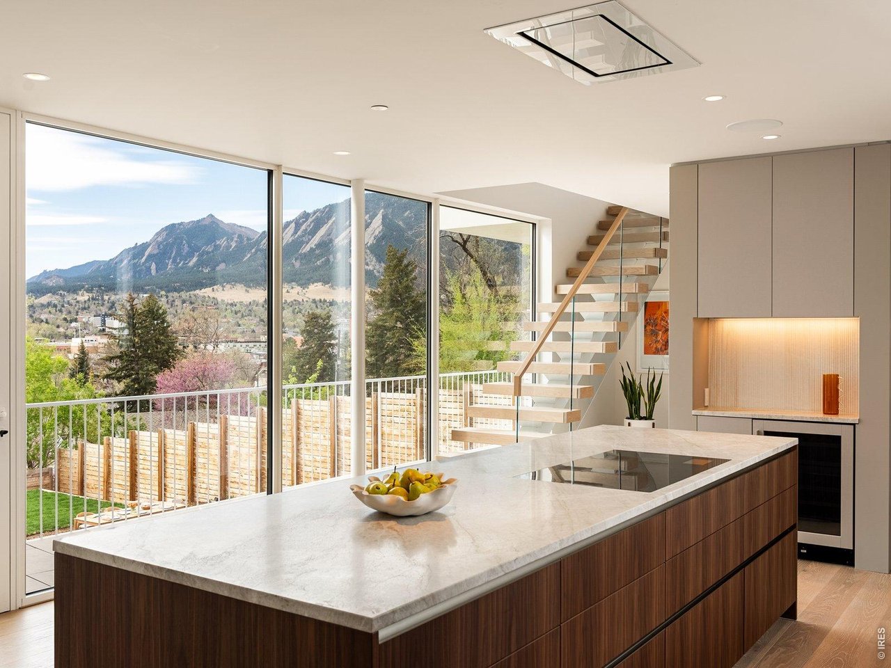 The curtain rises on 1750 Sunset Boulevard - a bold modern statement on one of Boulder's most coveted streets, where architecture and the Flatirons share center stage. Jaw-dropping views from each and every room give you - quite literally - a front row seat to the Flatirons. Designed by award-winning Tumu Studio, this architecturally striking residence opens to stunning Flatiron views through a 40-foot wall of Yawal triple-glazed sliding glass doors - and the entire landscape walks right in. Inside, Poliform Italian cabinetry and custom walnut paneling wrap the living spaces in quiet, understated sophistication. Taj Mahal quartzite throughout the kitchen glows in the afternoon light. Wolf, Sub-Zero, Bosch, and Fisher & Paykel appliances anchor the rest of the kitchen. Viewrail floating stairs, a Flare linear gas fireplace, and Lutron lighting and shades complete a thoughtfully curated interior. Everything in this residence is intentionally designed to sit quietly behind the Flatiron views that that command a standing ovation. The primary suite features smart-tint glass that shifts from clear view to opaque at a touch. Outside, there's a 20' heated pool alongside an exquisite Brown Jordan outdoor kitchen with Danver stainless components, and a gas fire pit extending the living space. Porcelanosa-paved decks are wired for speakers and overhead heating, while an upper-level green roof with automatic irrigation reminds you this home belongs to nature. Beyond the front door, Sunset Boulevard delivers a lifestyle to match the architecture - a premier Boulder address near world-class dining and shopping, with easy access to the city's best hiking, biking, and open-space trails.This is the showstopper on Sunset, where every room is a front row seat to Boulder's iconic mountain views. LIVE BOLDER, LOVE BOULDER!