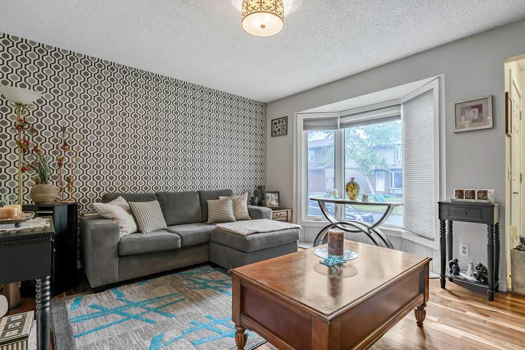 Welcome home! In 2021 this great three bedroom unit received a bright, new kitchen with an eating bar, backsplash, new vanity, and updated main bathroom. The main floor features hardwood and tile flooring. The woodburning fireplace in the living room makes a beautiful feature wall and you'll appreciate the convenient main floor powder room, perfect for guests. Upstairs you will find a bright and spacious primary bedroom featuring a generous closet with custom built closet organizer, as well as two more bedrooms and a 4 piece bath. The basement family room and flex room  have been partially developed and are ready for your personal touches. Outside, you will appreciate your own private, fenced yard with patio, leading to your parking stall. This townhouse complex is pet friendly with board approval.