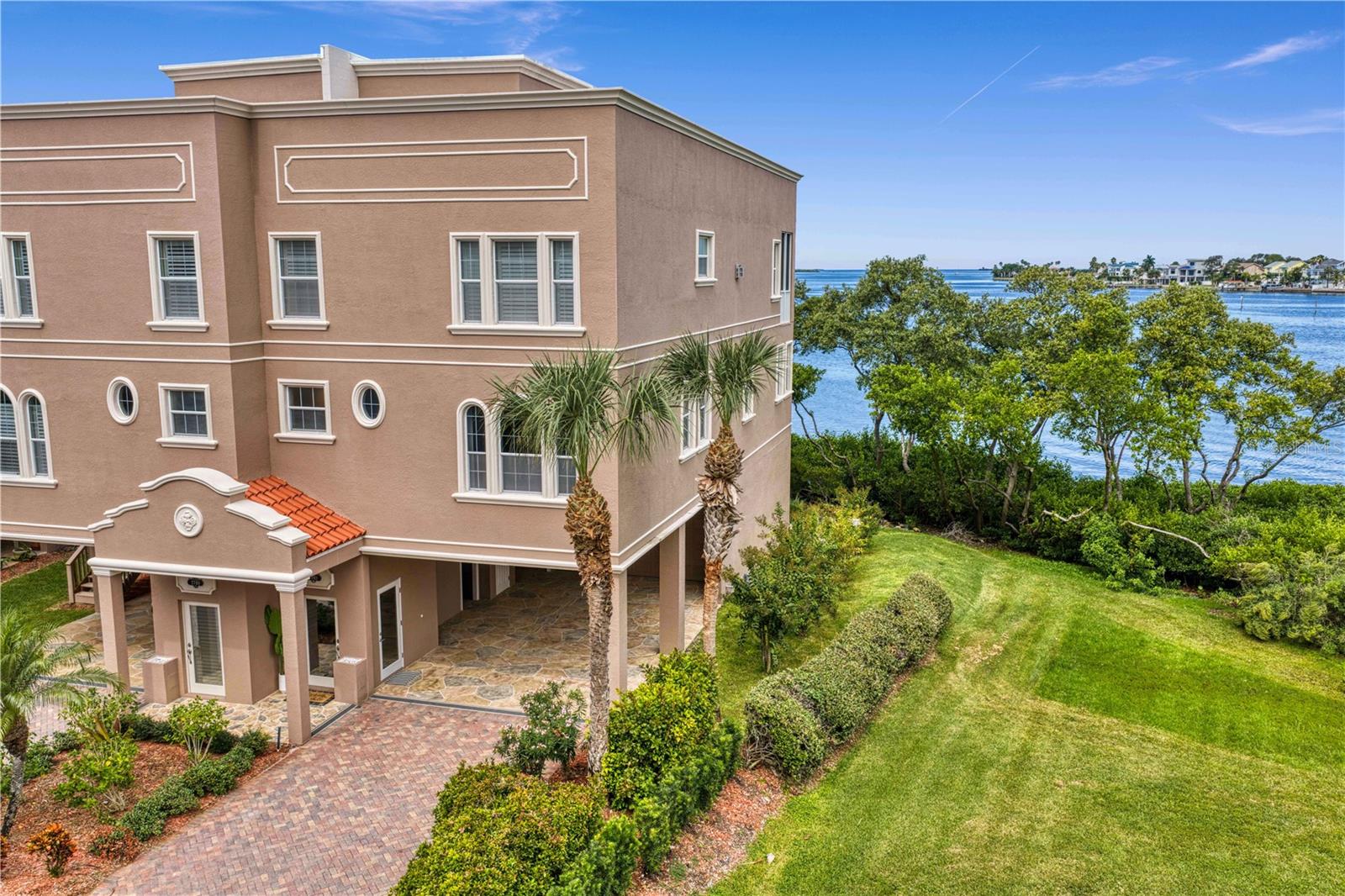 Virtually Staged. WELCOME TO WATERFRONT LIVING IN DUNEDIN! Rare opportunity to own this perfectly positioned premier end unit in The Reserve at Mediterranean Manors! This exceptional 4-bedroom, 3-bath residence offers 2,832 square feet of living space, incredible privacy with green space alongside the home, and BREATH TAKING PANORAMIC WATER VIEWS of St Joseph Sound from nearly every window. Enjoy ample parking with a 2.5 car garage and a private 4 car carport! Step inside and let the private elevator whisk you effortlessly between all four levels. Head upstairs to the main living level and prepare for the view to steal the show! Sweeping water vistas provide a spectacular backdrop to the spacious living and dining areas, while a private balcony invites you outside to enjoy the coastal breeze and soak in the most incredible sunsets! The kitchen opens to the main gathering spaces, making this level ideal for entertaining. Also located here is a fourth bedroom with double doors right next to a full bathroom—perfect as a home office, den, guest room or flexible living space. Continue to the third floor, where two generously sized secondary bedrooms accompany a truly special primary suite. Wake up to beautiful water views, step onto your private balcony for morning coffee, and enjoy two enormous walk-in closets and a spacious primary bath. Then head up one more level—and save the best for last. A wet bar welcomes you to the fourth floor before you step outside onto the expansive PRIVATE ROOFTOP TERRACE, an incredible extension of the home designed for entertaining, relaxing and taking in unforgettable Florida sunsets over the water. Whether it’s cocktails with friends, dinner under the stars or simply unwinding at the end of the day, this is the kind of outdoor living that makes every day feel like vacation. Additional features include: a BRAND NEW ROOF, two wet bars, a tankless water heater, 2021 A/C, Hurricane screens, wood flooring, an in-unit elevator serving all four floors. The lifestyle extends well beyond the home itself. The Reserve is part of waterfront Mediterranean Manors, with an array of community amenities including a private waterfront park and beach, heated pool, clubhouse, tennis, fishing, grilling areas, kayak access and more. And when you’re ready to explore, you’re just minutes from Honeymoon Island, the Pinellas Trail and vibrant Downtown Dunedin/Main Street, where locally loved restaurants, breweries, boutiques, festivals and waterfront destinations are all part of everyday life. This is the waterfront lifestyle you’ve been waiting for! Schedule your private showing today!