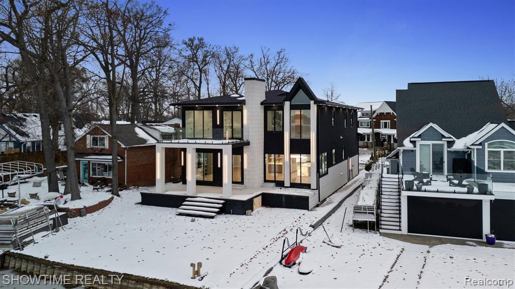 Experience a rare chance to own a brand-new luxury build on all-sports Lake Fenton — Sodded with a sprinkler system and a 5' Crawl space, crafted from the ground up with top-tier finishes. This isn’t your typical new construction; every detail was designed to stand out. As the tallest home on the street, it makes an immediate impression with a custom driveway and limestone entry steps. Inside, the foyer sets the tone with a soaring ceiling and double chandeliers. A custom wine display greets you before the office, and as we enter the living room, a massive Montego porcelain-slab fireplace centers the space while pulling you toward the covered lakeside patio. The kitchen offers a coffee bar, wine bar, Cristallo countertops, and a full Lighted Cristallo island paired with top-tier appliances. A second kitchen with a double convection oven keeps daily cooking simple. The garage was built for car lovers — designed to support a lift holding two additional cars for up to four total, and finished with fresh epoxy and added traction flakes.Upstairs, custom-lit stairs lead to four bedrooms, each with walk-in closets and private full baths. Convenience continues with two laundry rooms — one on the main floor and one upstairs. Two bedrooms, including the primary suite, overlook the lake, and the primary features a walk-out balcony perfect for morning coffee or peaceful summer nights. The primary bathroom and walk-in closet feel like a true retreat, crafted with stunning finishes and the kind of elevated detail that sets this home apart the moment you see it.Opportunities like this almost never hit Lake Fenton — true new construction, modern design, and craftsmanship that’s becoming harder to find each year. This home delivers a level of luxury, quality, and presence that buyers wait a while for. If you’ve been looking for something exceptional, something that genuinely stands out from everything else on the lake, this is your moment. Schedule your private showing today