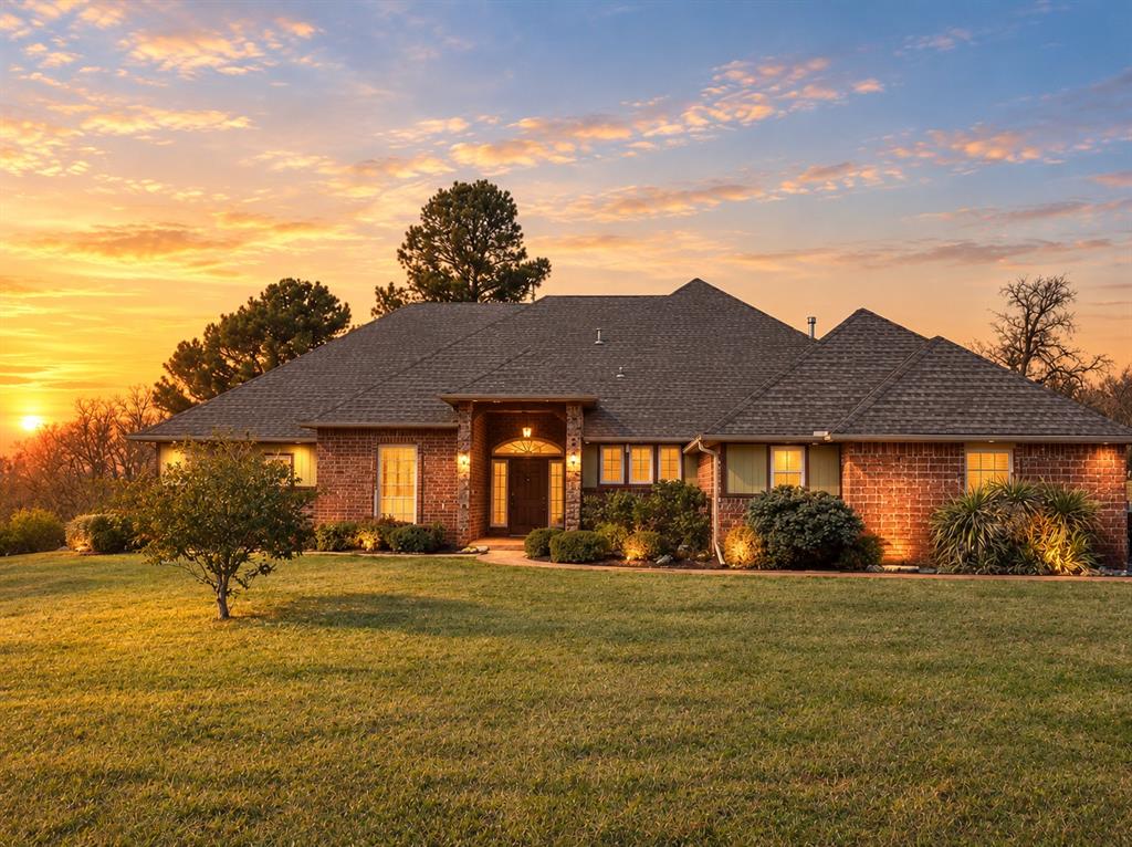 Beautiful single-owner brick home situated on a peaceful lot with mature trees and abundant natural light. Inside, the vaulted living room features exposed beams and a gas-burning fireplace, creating a warm and inviting atmosphere. The updated kitchen offers granite countertops, stainless steel appliances, and ample storage. The spacious primary suite includes an elegant bath with a relaxing soaking tub. Additional highlights include three bedrooms, two full baths plus two half baths, a large upstairs bonus room, a private office, and a spacious utility room with pantry space. Updated carpet and paint add a refreshed touch, while central heat and air provide year-round comfort. With its generous living spaces, classic brick exterior, and serene setting, this home offers a wonderful blend of comfort, character, and room to enjoy.