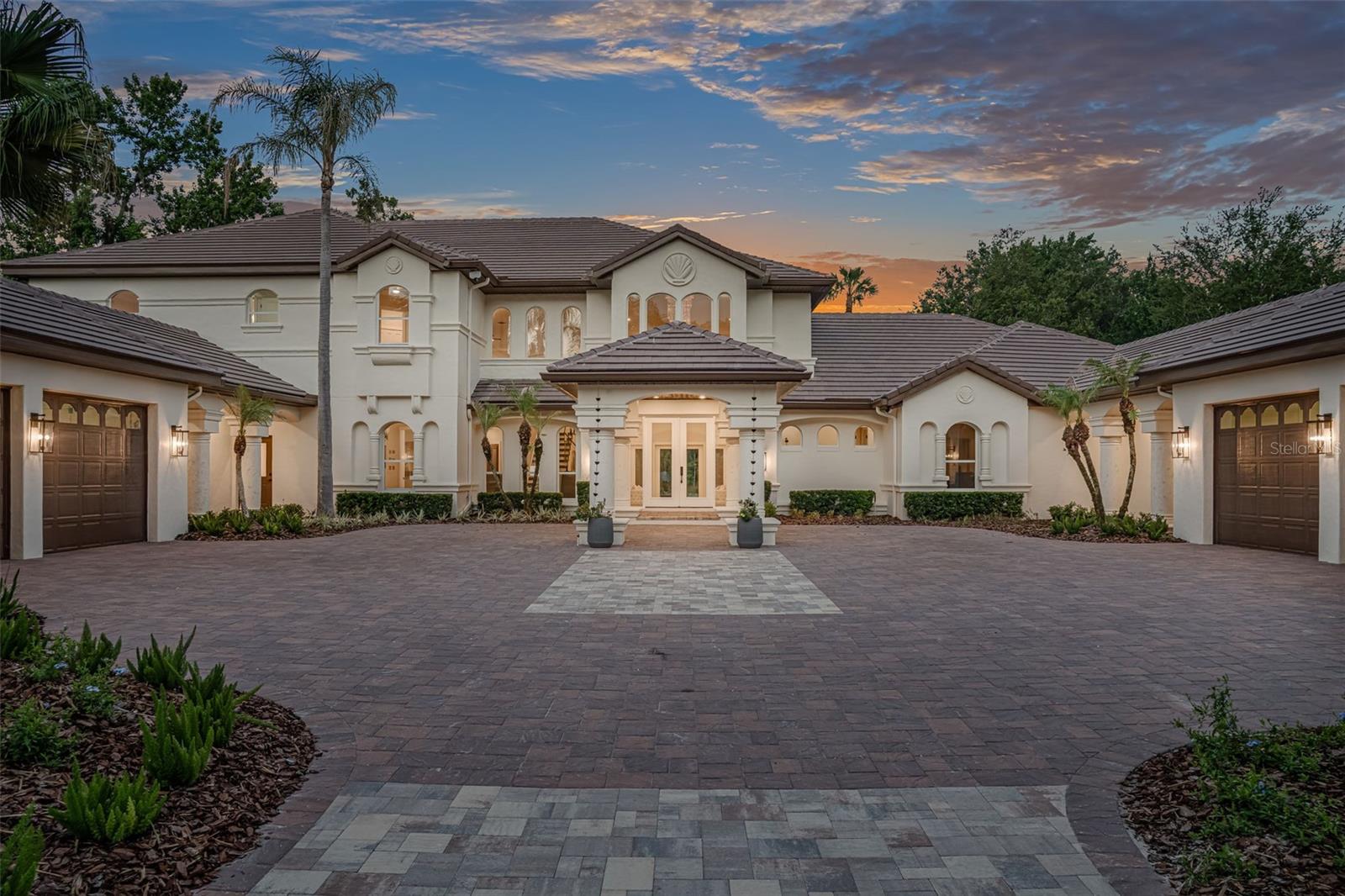 Renovated, remodeled & reimagined with breathtaking water views in Alaqua. An incredible opportunity to own a turn-key masterpiece nestled on a one-acre homesite in Seminole County's premier luxury 24-hour guard-gated neighborhood.  Skip the construction timeline and step directly into your dream home, ideally positioned within an established golf community. A brand-new brick-paver driveway and elegant porte-cochère set the tone for the extraordinary experience that awaits inside. Towering 24-foot ceilings in the grand foyer and living room invite an abundance of natural light while framing breathtaking views of the sparkling pool and tranquil, tree-lined pond beyond. Meticulously redesigned and crafted with uncompromising attention to detail, this exceptional residence seamlessly blends luxury, comfort, and functionality at every turn.  Upon entry, the basket-woven solid oak flooring blends with porcelain tile and hints at the seemingly never-ending upgrades found throughout the home.  At the heart of the home lies a showpiece kitchen worthy of a Michelin-star setting, featuring an expansive center island, hidden walk-in pantry, and a curated collection of premier appliances, including a Wolf 36” six-burner vented gas range, oven, steam oven, microwave, Sub-Zero built-in refrigerator, Cove dual dishwashers, and Perlick ice maker. Dining becomes an experience unto itself at 3147 Tala Loop. A dramatic custom light fixture anchors the dining room, complemented by a temperature-controlled walk-in wine cellar on one side and an intimate cocktail lounge with panoramic water views on the other. Privately situated on the main level, the primary suite is a retreat of unrivaled sophistication, offering dual spa-inspired bathrooms and two expansive custom walk-in closets designed for ultimate privacy and convenience. Outdoor living reaches resort-level perfection with over 1,000 square feet of covered lanai space showcasing a tongue-and-groove ceiling, brand-new summer kitchen, dedicated cabana-style pool bath, and outdoor shower—all overlooking a shimmering pool accented by three dramatic fire bowls. Even the utility spaces exude elegance, as the designer's laundry room features decorative cross beams, chandelier lighting, oversized utility sink, steam closet, and extensive custom storage. Upstairs, a spacious loft offers exceptional versatility and opens onto a 400+ square-foot balcony with sleek glass railings and uninterrupted water views. Four additional bedrooms, three full bathrooms, and a secondary laundry room provide exceptional comfort and convenience for family and guests alike. An ideal in-law or guest suite is privately tucked away on the main level, complete with its own bath, kitchenette, and sitting area. Completing this remarkable estate are an oversized four-car garage, basketball court, playground, and expansive fenced backyard—offering a rare combination of luxury, recreation, and everyday livability.  All this and more with incredible proximity to major highways, world-class shopping, dining, attractions, and great schools. This property may be under audio/visual surveillance.