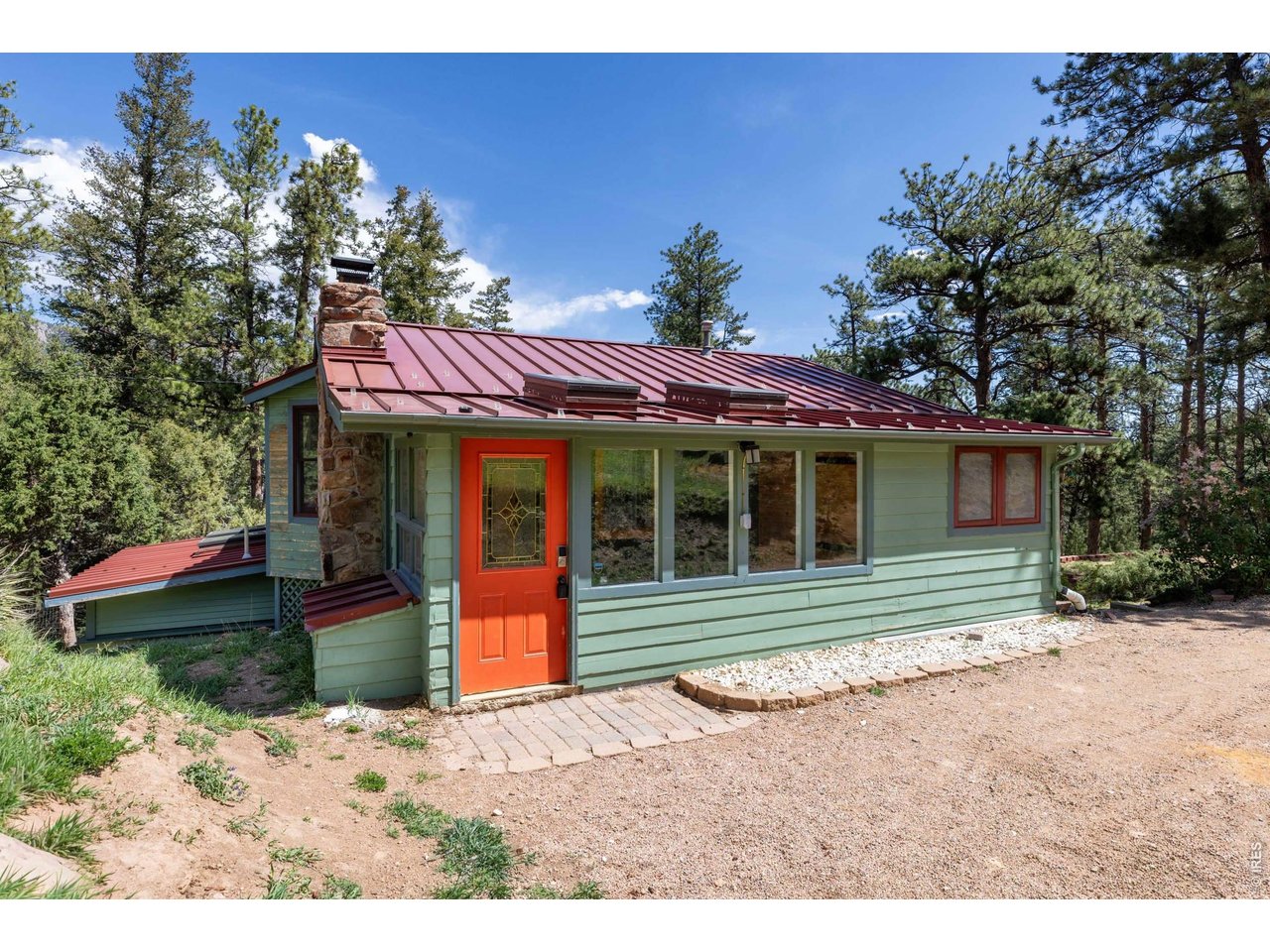Imagine walking out your back door to access MILES of Roosevelt National Forest trails. Get to the Little Thompson River directly from the backyard trail system. Welcome to your mountain retreat in desirable Estes Park Estates above Pinewood Springs; where privacy, nature, and adventure come together with NO HOA and EXCLUSIVE ACCESS to the Pinewood Springs swimming hole. This 1-acre hilltop lot home offers the quiet serenity and breathtaking scenery that make mountain living so special. Inside, the cheerful and inviting interior is filled with NATURAL LIGHT, skylights, tasteful updates, and a comfortable layout designed for both relaxing & entertaining. The sunny kitchen is a standout feature with granite countertops, custom cabinetry, stainless steel appliances, tile backsplash, and beautiful copper farmhouse sink. The main level includes a flexible bedroom ideal for guests or a home office; along with a bright mudroom/entry space and a glass-enclosed sunroom that lets you enjoy the outdoors year-round. Downstairs, the spacious primary suite offers a peaceful retreat complete with an adjoining bath, while the cozy family room WALKS OUT to a large deck overlooking the forest. Modern mountain conveniences add even more value, including high-speed FIBER INTERNET for easy remote work or streaming, a cistern for added peace of mind and dependable water storage, plus a BRAND-NEW UV filtration system which makes this a triple filtration water system. Surround yourself with hummingbirds, towering pines, fresh mountain air, and the soothing sounds of nature. Whether you enjoy hiking, gardening, fishing nearby rivers, or simply soaking in the mountain views, this property delivers an unmatched Colorado lifestyle. Located just 10 minutes from downtown Lyons, under 20 minutes to Estes Park, and a short drive to Rocky Mountain National Park; you'll enjoy easy access to dining, shopping, and endless outdoor recreation.