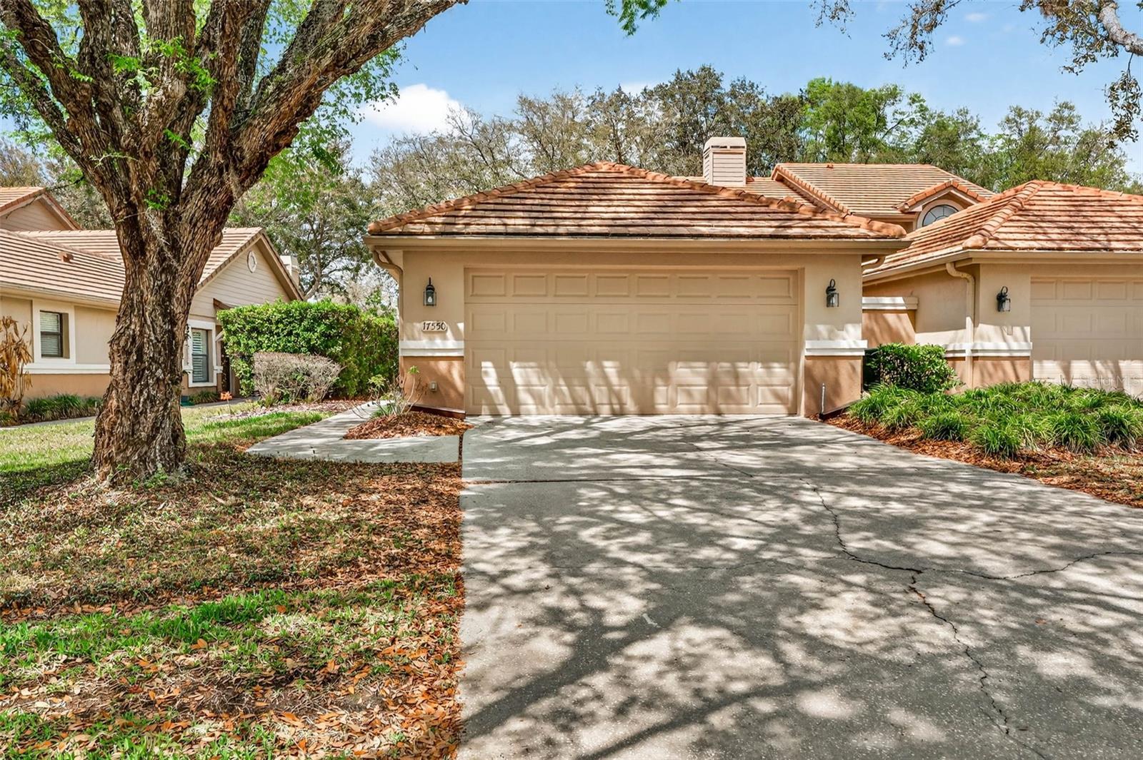 Located in the highly sought-after, guard-gated Hunter’s Green community in New Tampa, one of the most desirable master-planned neighborhoods in the area, this beautifully maintained maintenance-free villa offers comfort, privacy, and convenience. The thoughtfully designed split floor plan features vaulted ceilings, a spacious living area, and elegant plantation shutters throughout all bedrooms.The primary suite provides a peaceful retreat and includes a custom closet organizer, a well-appointed ensuite bath, and access to a private courtyard, creating a quiet outdoor space perfect for morning coffee or relaxation.Recent updates make this home truly move-in ready, including a new AC system, new carpet, new washer and dryer, and an additional refrigerator for added convenience. Step outside from the living and dining areas to a screened patio with inviting pavers, ideal for relaxing or entertaining while enjoying the peaceful surroundings and Florida lifestyle. Residents enjoy access to two community pools: a private gated Oak Crest pool located just a few homes away, as well as the larger Hunter’s Green community pool and recreation amenities. Hunter’s Green offers an exceptional lifestyle with 24-hour guard-gated security, golf course, tennis and pickleball courts, basketball courts, soccer fields, playgrounds, walking trails, and dog parks. The community country club also offers optional memberships with access to a junior Olympic-size pool, waterslide, fitness center, and dining facilities.Ideally located with easy access to I-75, and just minutes from USF, Moffitt Cancer Center, shopping, dining, and entertainment, the home is also zoned for top-rated New Tampa schools. This home combines peaceful living with unmatched convenience in one of Tampa’s most sought-after communities. Schedule your private showing today.