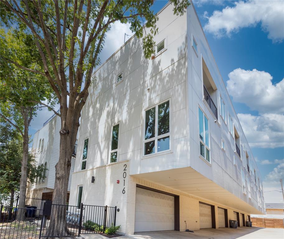 Upscale finishes define this stunning end-unit condo, featuring 11-foot ceilings and expansive windows that flood the space with natural light. The home is brightened and modernized with light-filtering roller shade window treatments, decorative lighting, and crisp white finishes throughout.     Located in the highly desirable Knox-Henderson area, this 2-bedroom, 2.5-bath condo with a 2-car garage places you within close proximity to some of Dallas’ most popular restaurants, boutique shopping, and lively nightlife—perfect for enjoying vibrant urban living.    The open-concept layout is designed for entertaining and showcases high-end features, including a gas fireplace that anchors the living area.     The gourmet kitchen impresses with quartz countertops, a glass subway tile backsplash with a hexagon pattern above the cooktop, a stainless steel farmhouse sink with pull-down sprayer, Whirlpool stainless steel appliances (gas range, dishwasher, and built-in microwave), soft-close white cabinetry with nickel hardware, under-cabinet lighting, and decorative pendant lighting. Rich hardwood flooring flows throughout the main living areas, hallways, and stairs.    Additionally, recently installed carpet enhances both bedrooms.  The primary suite offers a private balcony and a spa-inspired bath: an enclosed glass shower with penny tile flooring and designer lighting.     Enjoy incredible Dallas skyline views from the private rooftop terrace, an ideal space for relaxing. Additional features include Nest thermostats, decorative ceiling fans on the second and third floors, and a laundry closet with built-in shelving. The attached 2-car garage includes a Navien tankless water heater (temperature adjustable), LiftMaster garage door opener, five wall outlets, a large storage niche, and fire sprinklers throughout the condo.     The HOA covers water, sewer, and trash, and the property offers quick access to Hwy 75, making commuting throughout Dallas convenient.