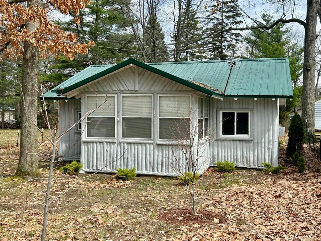 Well-maintained and full of rustic knotty pine charm, this updated log cabin sits within 2 blocks from beautiful Houghton Lake. At end of street a boat launch for lake access. Offering 1 bedroom and 1 full bath, this cozy getaway also features a detached 16' x 24' insulated garage with storage above, providing plenty of room for your ATV, golf cart, fishing boat, and other Up North toys. Numerous updates have been completed within the last five years, including a new metal roof, well pump, pressure tank, hot water heater, refrigerator, wall furnace, and new sunroom windows for evening relaxing. Blending classic cabin character with the comfort of modern updates, this property offers the perfect Up North retreat walking distance to the largest inland lake in Michigan and all the recreational opportunities for summer fun swimming, fishing, boating, jet ski, winter snowmobiling, and Houghton Lakes Tipup Town !