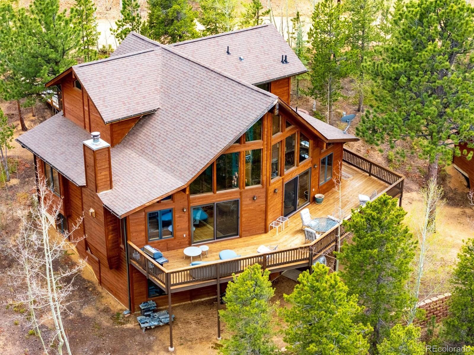 Nestled in the serene beauty of the Colorado Mountains, this custom, one owner home, offers the perfect blend of comfort, quality privacy and breathtaking scenery.  Set on just over an acre of wooded land,surrounded by towering pines creating a peaceful private retreat with majestic views.Inside, this spacious 3300 square foot home features 4 plus bedrooms and 3 baths, thoughtfully designed for both everyday living and entertaining.  A dramatic entry welcomes guests with soaring ceilings with an impressive sense of arrival. The open concept layout flows seamlessly into an expansive great room creating an inviting atmosphere for dining and entertaining.The open layout is filled with natural light and showcases the surrounding landscape from nearly every angle, with 10 x 40 deck for outside entertaining and enjoyment The heart of the home is a beautifully designed gourmet kitchen  with charming greenhouse window, featuring custom cabinetry, immaculate hard wood flooring  elegant stone countertops and center island for meal prep and casual seating .. complimented by a generous walk in pantry, separate laundry mud room area with utility sink, built in desk w/additional house entry.The lower walk out level offers additional recreation  room area  with woodstove and features 2 guest suites plus office area loaded with warmth and spaciousness offering flexibility for family and guests as the expansive views invite the outside in.The extra wide staircase leads you to the private upper level  master suite, providing a relaxing escape with its own 5 piece sparkling, spa bath w/ enormous walk in closet and exclusive balcony.  One of the Standout features  is the HUGE  detached garage with work shop  plus additional attic space,  ideal for hobbyists or outdoor enthusiasts needing space for vehicles and gear.Whether you are enjoying quiet mornings on the deck or taking in the expansive mountain vistas.  This property delivers a Colorado lifestyle at its finest.