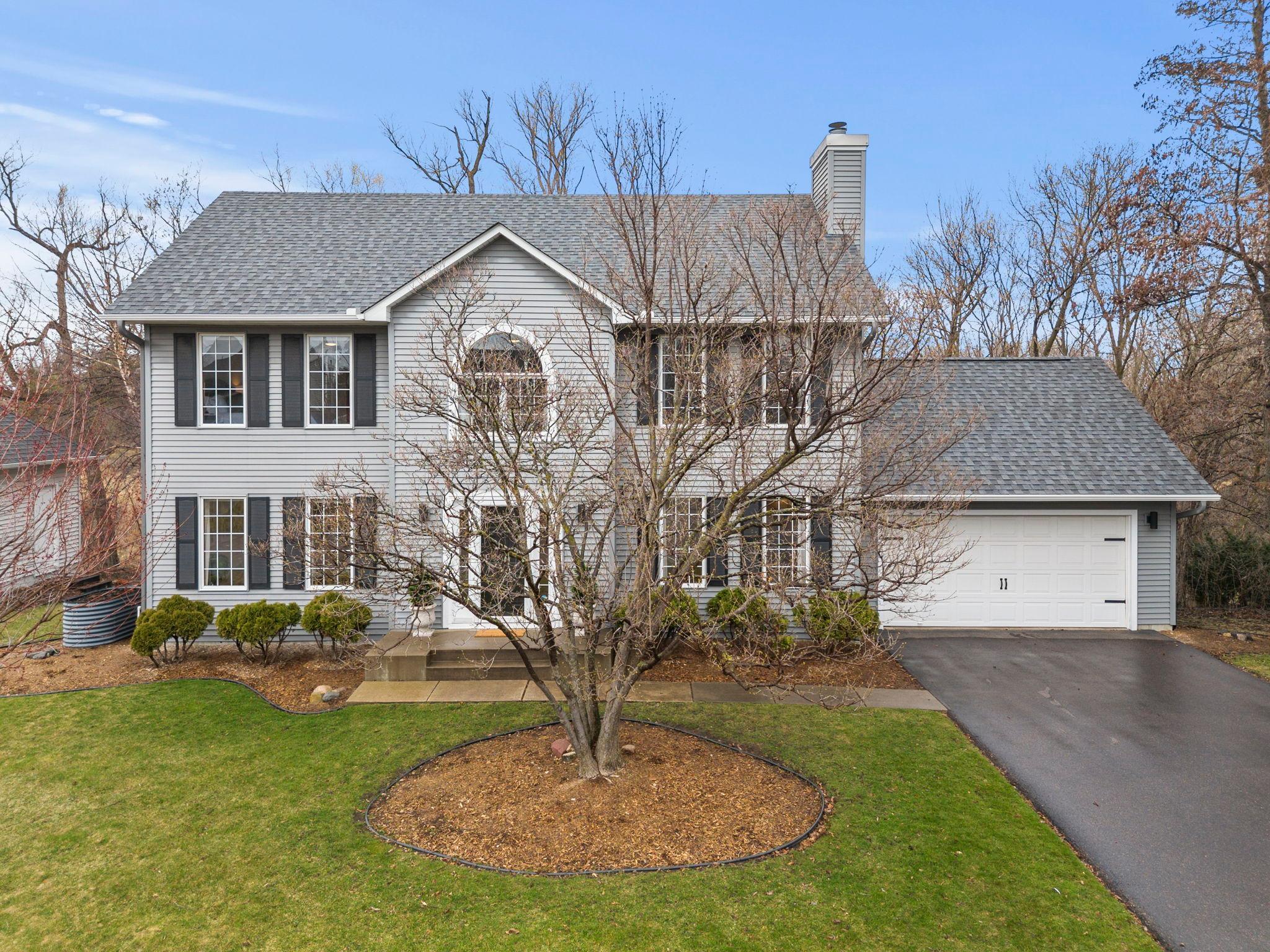 Stunning updated five bedroom, four bathroom move in ready home in a quiet Plymouth neighborhood near parks, trails, dining, and shopping. The fully remodeled 2024 kitchen features white cabinetry, luxury plank flooring, stainless steel appliances, a gas cooktop, tile backsplash, and a large center island with breakfast seating, opening to both formal and informal dining areas. Enjoy wooded and pond views from the screened and covered deck just off the informal dining space. The main level offers a cozy living room with a fireplace, renovated half bathroom, and a convenient laundry and mudroom with garage access. Upstairs includes four bedrooms with a spacious primary suite, walk in closet, and private bathroom. The renovated walkout lower level adds a large family and recreation space with a fireplace, updated bar area, fifth bedroom, three quarter bathroom, and ample storage. Additional updates include a new washer and dryer (2023), water heater (2023), water softener (2024), furnace blower fan (2024), and new oven, microwave, cooktop, and dishwasher (2024). The main level was also enhanced in 2024 with new knockdown ceilings and recessed lighting, adding a fresh, modern finish. Don’t miss the opportunity to own this beautifully updated home in an exceptional Plymouth location.