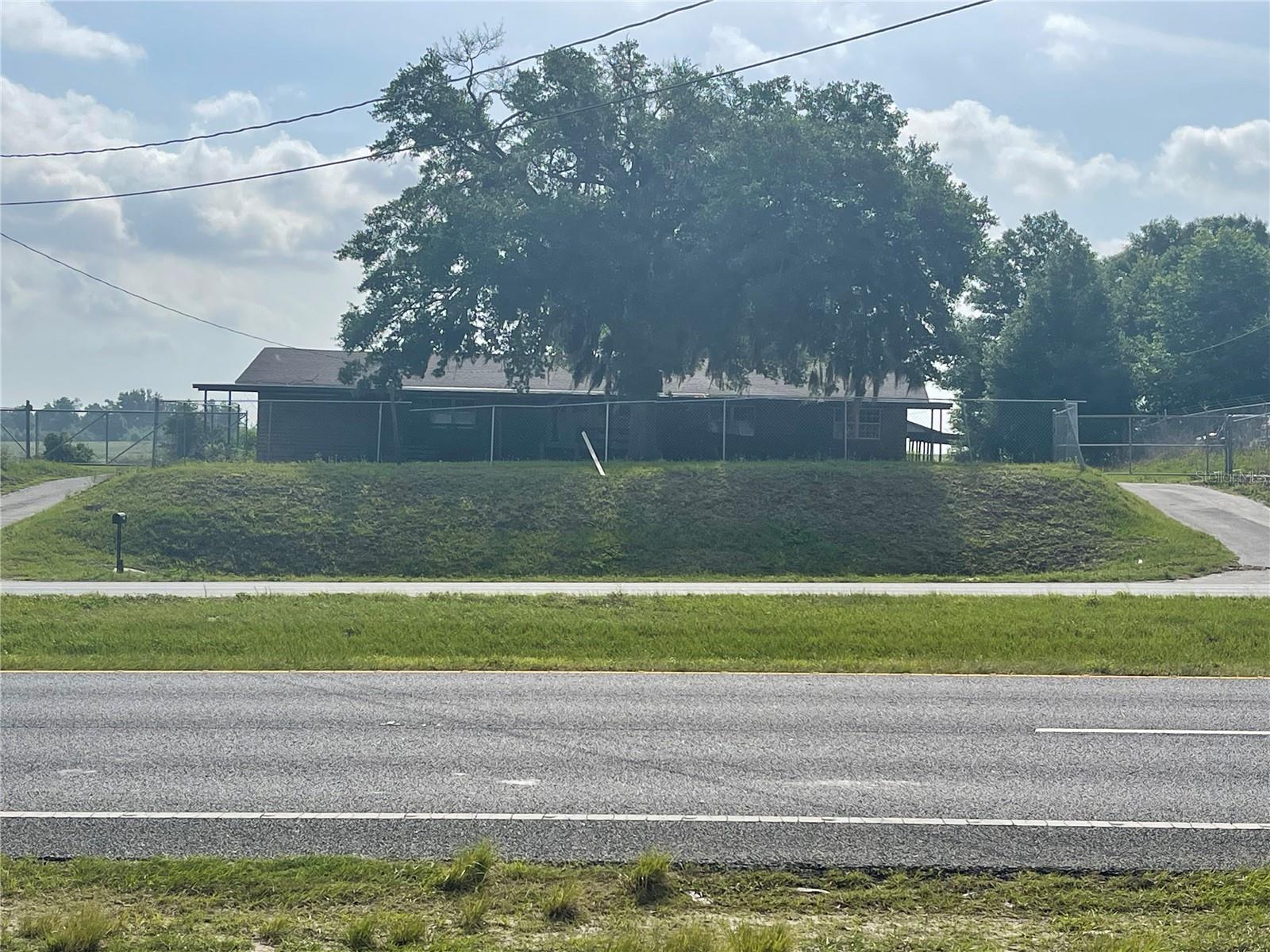 Excellent C2 zoned location in county for various uses. This property is located on a major Hwy with great visibility, making it an ideal location for a used car lot, office, day care etc...  Covered parking for 5 vehicles in front and 4 covered parking places in the rear which could be used for service or repairs. Over 5000 sq. ft of covered space.  2 access drives from US 301.  Building is a refurbished house with new roof.  200-amp service / upgraded electric.  Two RV service sites with electric, water and common dump station. 6' Chain link fence.  Seller will consider a long term lease.