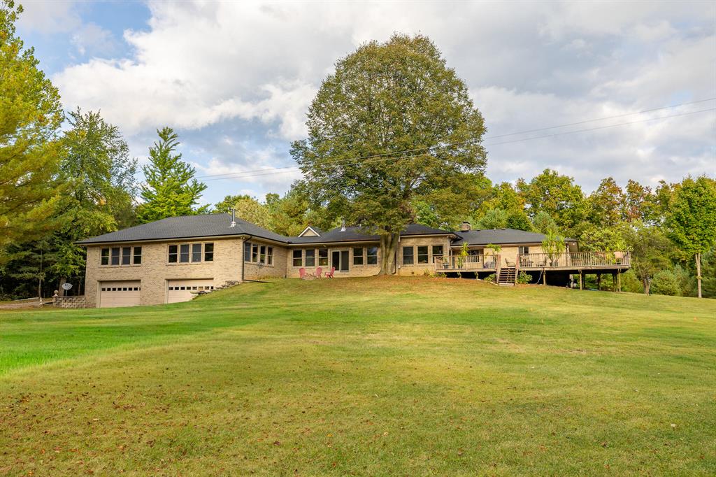 Discover an extraordinary brick ranch estate, privately set behind a gated entrance on ten breathtaking acres in Dexter. This exceptional property offers a rare combination of natural beauty and refined living, with rolling hills, mature woods, walking trails, Arms Creek running through the property with a picturesque bridge, and a large stocked pond that creates a serene backdrop for daily life. A welcoming front porch invites you to take in the sights and sounds of nature, while inside, the home is thoughtfully designed for both elegance and flexibility. One wing functions as a private retreat or mother-in-law suite, showcasing hardwood floors, a dramatic wall of windows, a wood-burning fireplace, billiards area, wet bar/kitchen hookups, and a spa-inspired bathroom with a tiled shower, soaking tub, and walk-in closet. The opposite wing offers a warm living room with a fireplace with sandstone surround, a chef's kitchen with granite countertops, center island breakfast bar, and cherry cabinetry, three spacious bedrooms, and two more full bathrooms. A breezeway with wood stove serves as a stunning dining space, opening through a slider door to a large deck that overlooks the grounds. The walkout lower level extends the living area with recreation space, a half bath, laundry area, and access to a concrete patio. Recent updates include a brand-new roof (2024), new gutters and downspouts (2024). The estate is further complemented by an attached two-car garage, a lower-level four-car garage with workshop, andmost notablya spectacular 72' x 40' barn constructed by Burly Oak Builders in 2021. This remarkable structure boasts a full concrete floor, second level with dormer, and an inviting 8-foot-wide porch that perfectly frames sweeping views of the pond, making it an extraordinary space for entertaining, storage, or future customization. This gated sanctuary blends the comforts of luxury living with the beauty of a private country retreat. Interior Photos Available Thursday. Showings start Friday, 9/26/25.