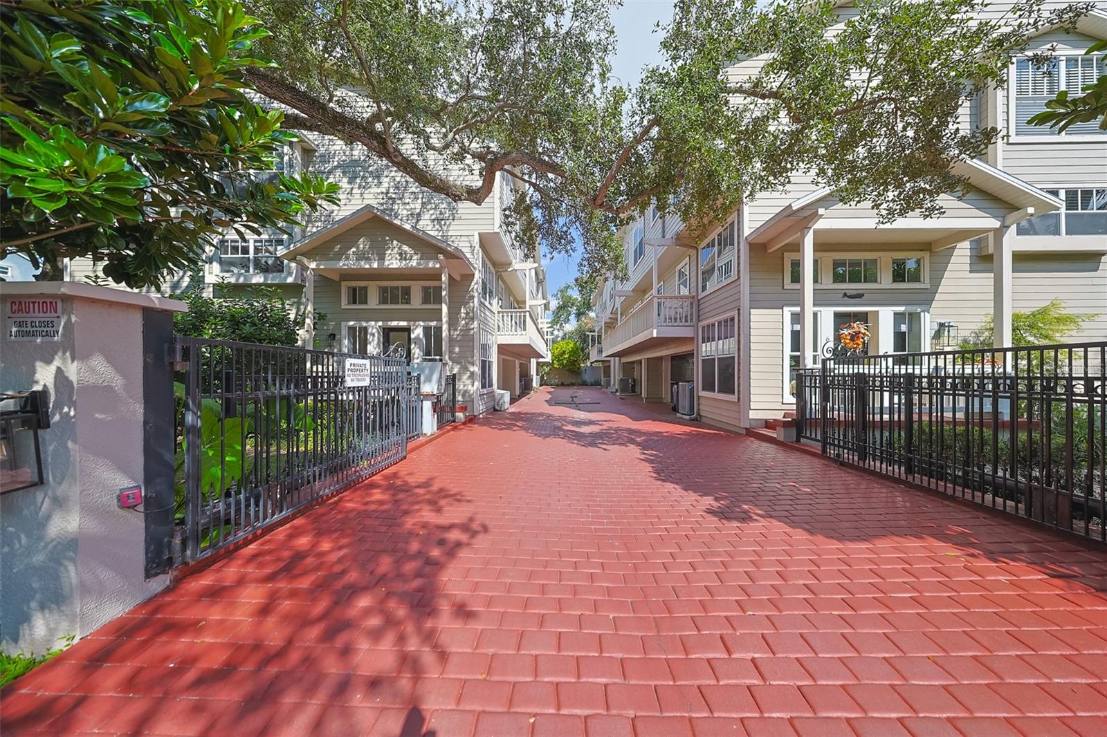 Welcome to Palm Place, an exclusive gated community in South Tampa offering paved driveways, guest parking, and a prime location just steps from SoHo and Bayshore Boulevard. This luxury townhouse showcases an open floor plan with 13-foot ceilings, elegant crown molding, and a wood-burning fireplace with a new custom mantle. French doors lead to a private outdoor area with new composite decking, perfect for relaxing or entertaining guests. The kitchen, fully updated in 2022, features premium stainless steel appliances, quartz countertops, a spacious island, a wine refrigerator, and modern recessed lighting. It flows seamlessly into the expansive dining area with a tray ceiling and decorative molding, overlooking the living room below. Beautiful wood floors extend throughout the home, adding warmth and sophistication to every space. The primary suite boasts vaulted ceilings, a walk-in closet with custom built-ins, and a spa-like bathroom complete with a dual-sink vanity, frameless glass shower, soaking tub, and heated floors. Both additional bedrooms feature vaulted ceilings, with one offering a walk-in closet and Jack-and-Jill bathroom access. The home also includes a large two-car garage and a convenient upstairs laundry area located near the bedrooms. Recent updates include a new AC system (2018), WATER HEATER (2020), and WATER SOFTENER (2022). Best of all, this property is not located in a flood X, meaning NO flood insurance is required. Zoned for the highly sought-after Plant High School, this home offers unbeatable convenience near Hyde Park, Downtown Tampa, and Channelside. Experience the best of luxury living in South Tampa — schedule your private showing today!