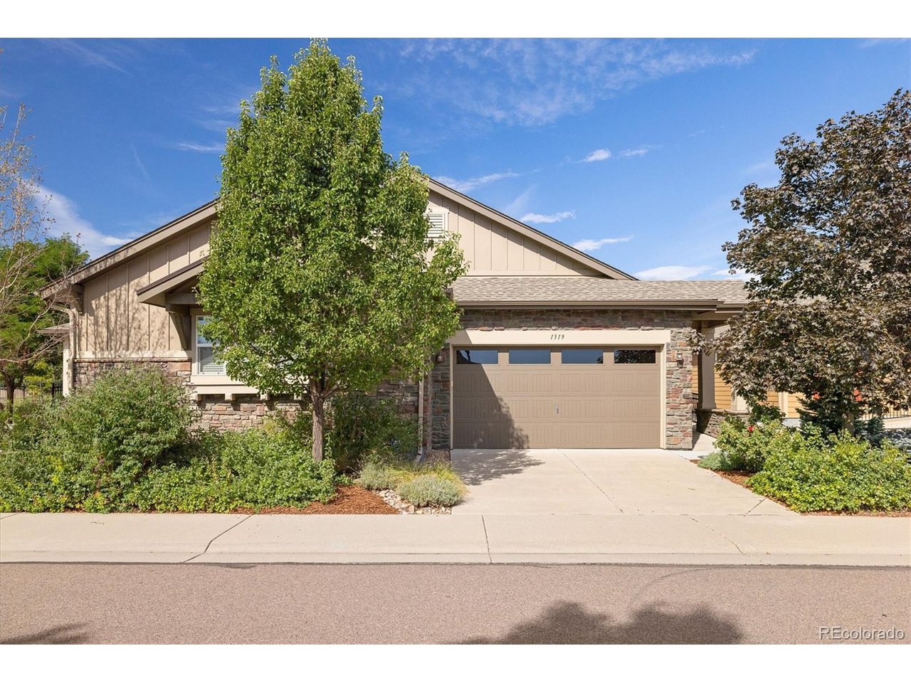 Welcome to 1319 Lander Lane, where comfortable main-level living meets an easy lock-and-leave lifestyle in one of Lafayette's most convenient locations. This beautifully maintained ranch-style paired home offers a thoughtful floor plan, flexible living space, and HOA-maintained exterior care, landscaping and snow removal.The heart of the home is the open kitchen, dining and living area, where hardwood floors, vaulted ceilings and abundant natural light create a warm and inviting feel. The kitchen features granite countertops, stainless steel appliances, a gas range, generous cabinetry and a large center island with seating, ideal for everyday living and entertaining. The living room centers around a gas fireplace and opens to the covered back patio for an easy indoor-outdoor connection.The spacious main-level primary suite is tucked away for privacy and includes an ensuite bath and large walk-in closet with built-in shelving. A particularly thoughtful feature is the adjoining laundry room, located just off the kitchen while also providing direct access to the primary closet and ensuite bath.A second bedroom and full bath on the main level offer flexibility for guests, a home office or additional living needs.Downstairs, the finished family room provides plenty of room for movie nights, hobbies, a game area or additional gathering space. A third bedroom and full bath create a comfortable private space for guests, while the unfinished portion of the basement provides substantial storage and future possibilities.Located in Coal Creek Villas, the home is within walking distance of Old Town Lafayette, with convenient access to local restaurants, shops, trails and everyday amenities while still feeling tucked into an established neighborhood.With main-floor living, a flexible finished basement, covered outdoor space and a floor plan designed to make daily life easier, 1319 Lander Lane offers comfort and convenience in a setting that is easy to enjoy.
