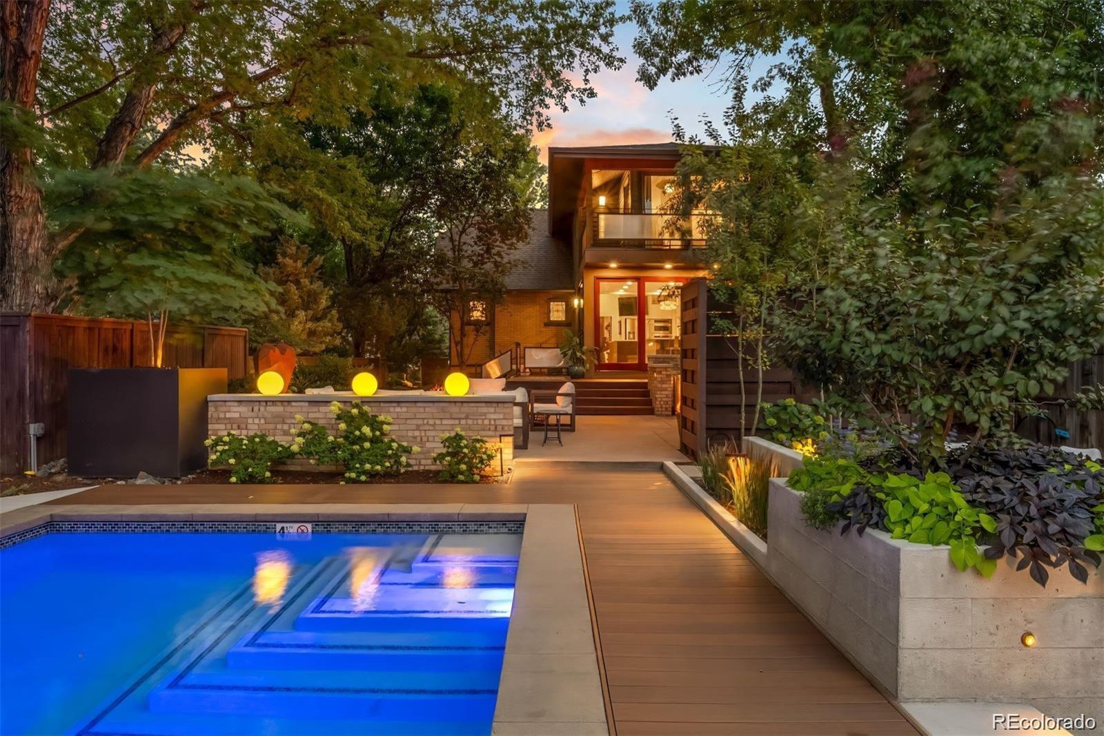 On one of the quietest, tree-lined blocks in Potter Highlands, this property delivers an outdoor living experience that rivals the Denver Botanic Gardens. The professionally designed grounds feature a resort-style heated pool with UV/ozone sanitization, LED lighting, and electric child-safe cover; a built-in natural gas outdoor kitchen with custom lighting; bocce ball court; and a natural gas outdoor fireplace. Two cast concrete water features add tranquil ambiance, while custom ornamental steel fencing—crafted by the late artist Dennis West—frames the front and side yards. The privacy fence is horizontal cedar, blending warmth with artistry. A detached 250 sq. ft. climate-controlled studio serves as a music room, office, or creative retreat with wall-mounted A/C and baseboard heat. The home also offers 716 SqFt of garage space (just shy of a 3 car garage).Inside, character and updates meet in harmony. The kitchen features a coffee bar, beverage fridge, LG convection oven, Bosch dishwasher, and Samsung refrigerator. Original stained glass and woodwork pair beautifully with newer doors, storm windows, and a refreshed interior. Upstairs offers three spacious bedrooms and two full baths, while the main floor hosts a guest suite with adjacent bath. The finished lower level is a private apartment with separate entrance, full kitchen, laundry, egress, and dedicated heating/cooling—ideal for guests, rental income, or multigenerational living. Extensive updates include two newer furnaces, central A/C, basement mini-split, tankless water heater, updated plumbing and electrical, WiFi leak detection, and newer aluminum-clad windows.  The Potter Highlands historic neighborhood is home to some of the best restaurants and cafes in town. Steps from Spuntino, Bar Dough, and Kumoya, this rare offering combines outdoor luxury, flexible living, and one of Denver’s most sought-after locations. ADU plans included.