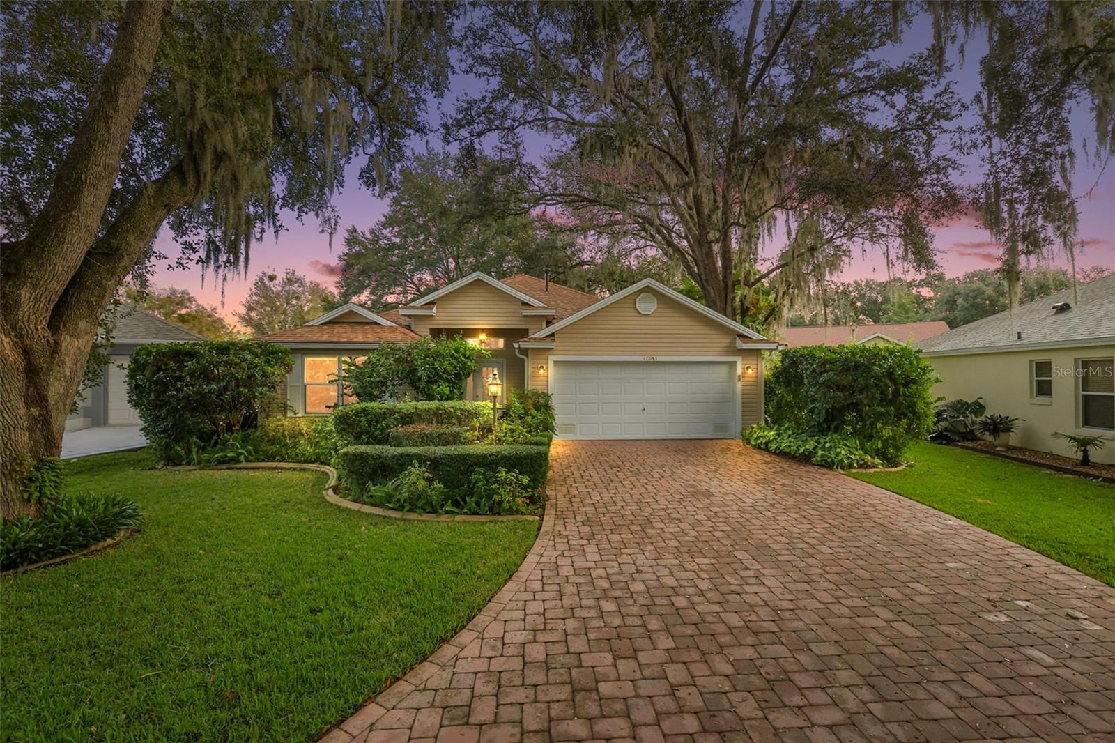 GORGEOUS 3/2 RARE Ligustrum Model, nestled within a QUIET CUL-DE-SAC on a LARGE PRIVATE LOT in the highly desirable Village of Woodbury! LOW BOND - only $1,389! ROOF (2019), HVAC (2019), HWH (2020). STATELY oaks and MATURE landscaping with CURBED edges; PAVER drive and walkway; COVERED entry vestibule; and a front door with built-in blind, retractable screen, sidelight, and transom window welcome you in to a well-lit and generous foyer boasting HIGH CEILINGS a convenient ENTRY CLOSET. UPGRADES include FRESH interior paint and SEAMLESS, LIGHT WOOD-GRAIN LUXURY VINYL PLANK THROUGHOUT the ENTIRE home! The AMAZING kitchen boasts WOOD cabinetry with PULL-OUTS, GRANITE countertops, built-in PANTRY, and a convenient EAT-IN breakfast bar. Adjacent to the kitchen, the dinette area, with its VAULTED ceiling and ample windows invites natural light. The EXPANSIVE OPEN CONCEPT living and dining area features HIGH CEILINGS creating a SPACIOUS and voluminous main living area - perfect for gatherings and entertaining! From the living room, sliding glass doors invite you in to the SPACIOUS 23’ x 8’ lanai overlooking the LARGE rear yard surrounded by mature landscaping, creating abundant PRIVACY! There’s also a side PAVER patio for grilling or simply enjoying the beautiful Florida weather! Back inside, an arched doorway leads you to the primary bedroom boasting a VAULTED ceiling, abundance of windows, sliding glass doors to the lanai, and a generous WALK-IN closet. Its en-suite bathroom features WOOD cabinetry, TILED WALK-IN shower, and a LINEN closet. Two additional bedrooms and a second bathroom are conveniently located near the front of the home ensuring plenty of PRIVACY for guests or a quiet home office. Bedroom two features large double windows and TWO built-in closets. The second bathroom is well-appointed with a WOOD vanity, TILED tub and shower combination, and a hallway LINEN closet. The third bedroom offers double windows and a built-in closet. Just off of the kitchen, an INTERIOR laundry room features a utility sink and shelving and leads to the two-car garage offering pull-down stairs with attic access, workbench, and additional STORAGE shelving. DON’T MISS THE OPPORTUNITY TO MAKE THIS INCREDIBLE HOME YOUR OWN! The Village of Woodbury is IDEALLY LOCATED close to Nancy Lopez Legacy Country Club and Championship Golf Course; Glenview Country Club and Championship Golf Course; Mulberry Grove Recreation Center; First Responders Recreation Center; First Responders Pitch-N-Putt Golf Course; Springdale Fitness and Walking Trails; Mulberry Dog Park; and Hwy 441 and CR 466, offering an abundance of shopping, dining, banking, medical, and more! PLEASE WATCH OUR WALKTHROUGH VIDEO of this FABULOUS  HOME and call today to schedule your Private Showing or Virtual Tour!