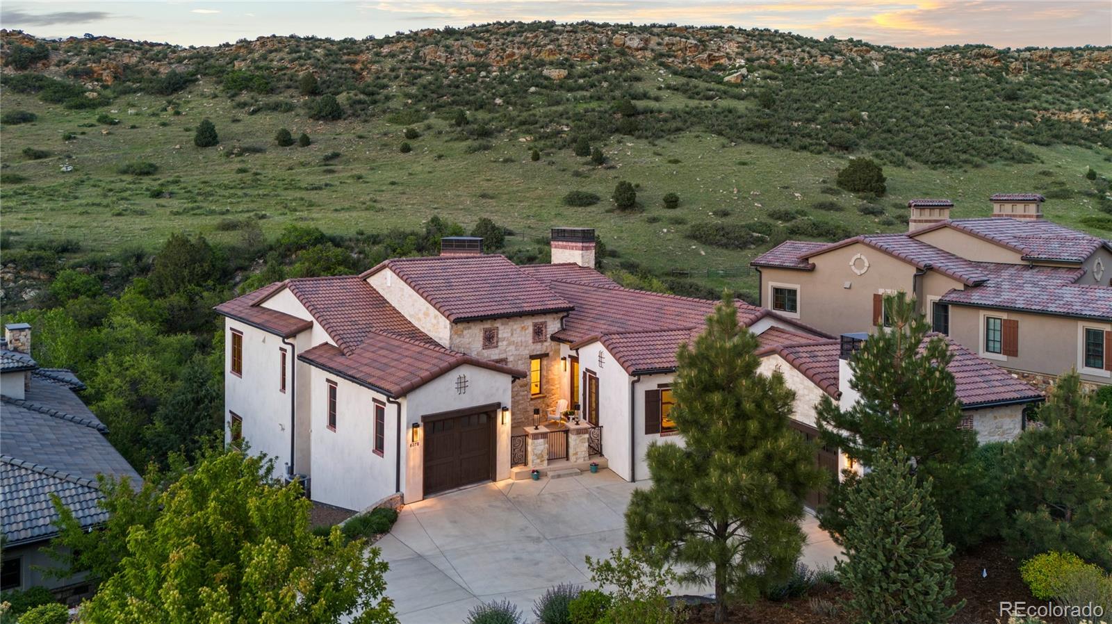 Experience the comfort and elegance with this beautiful blend of luxury and livability in one of Colorado’s most desirable settings. Located within the exclusive gates of Ravenna Country Club, extensively updated throughout this Mountain Modern home offers 4,661 square feet of contemporary modern living spaces and a spacious 3-car garage. Significant upgrades include: Expanded Kitchen island with new countertop, marble backsplash, fresh paint, rod iron railings, white-washed brick accents, newly installed GENERAC 26KW backup generator, all-new designer light fixtures lend a modern, refined feel, complemented by a completely remodeled powder room on the main level. The open-concept great room, kitchen, and dining area provide seamless flow for everyday living and gatherings. Outdoor living is elevated with a stunning wraparound covered deck finished with pavers and a built-in outdoor kitchen—ideal for hosting while taking in the surrounding natural beauty. The expansive primary suite boasts a spa-inspired bath and a walk-in closet with custom built-ins, balancing style and functionality. A private office with French doors and courtyard views offers a tranquil, inspiring workspace. The finished lower level includes two additional bedrooms and bathrooms —one featuring custom-built bunk beds that comfortably sleep four—and a guest suite with its own bathroom.  Additional highlights include a wet bar, flexible space for a wine cellar or exercise room, and an oversized covered patio with a private gas fireplace. Enjoy refined finishes, serene views, privacy, abundant wildlife, and the best of Colorado living in this exceptional home.