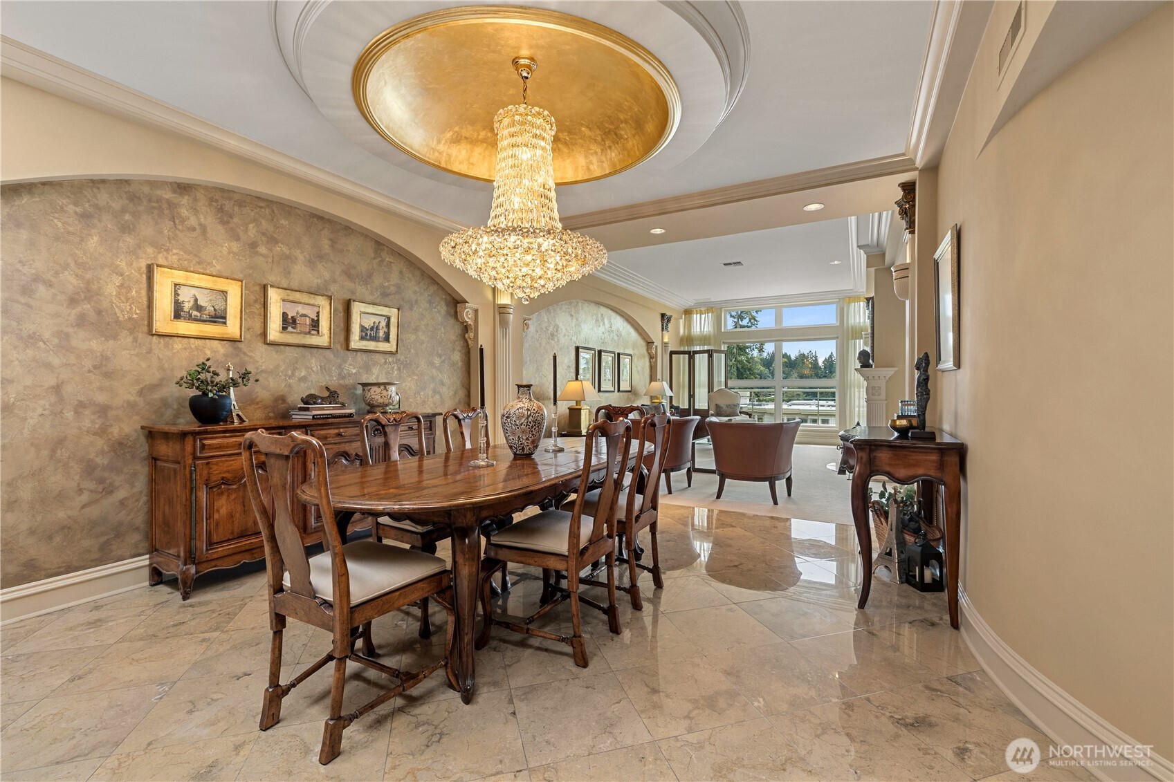 Set within an intimate six-residence building one block from Meydenbauer Bay Park, this Old Bellevue penthouse pairs gracious one-level living with exceptional custom craftsmanship. Ten-foot ceilings, five skylights, and a southwest-facing terrace bring natural light and seasonal views of Lake Washington, Mercer Island, and Mt. Rainier.      A gold-leaf dining dome, raw silk wallcoverings, bespoke millwork, and hand-painted Italianate details create a richly layered interior, complemented by heated marble and travertine floors. The kitchen features a French Lacanche range, Sub-Zero refrigerator, double Dacor ovens, and wine refrigeration. The formal dining room accommodates seating for up to 18.      The original three-bedroom layout was reimagined to create an expansive primary retreat with a boutique-style dressing room, steam shower, and jetted tub. A semi-private elevator landing, two secure parking spaces, and a generous wine celler / private storage room complete the home, moments from Main Street dining, shopping, and the waterfront.