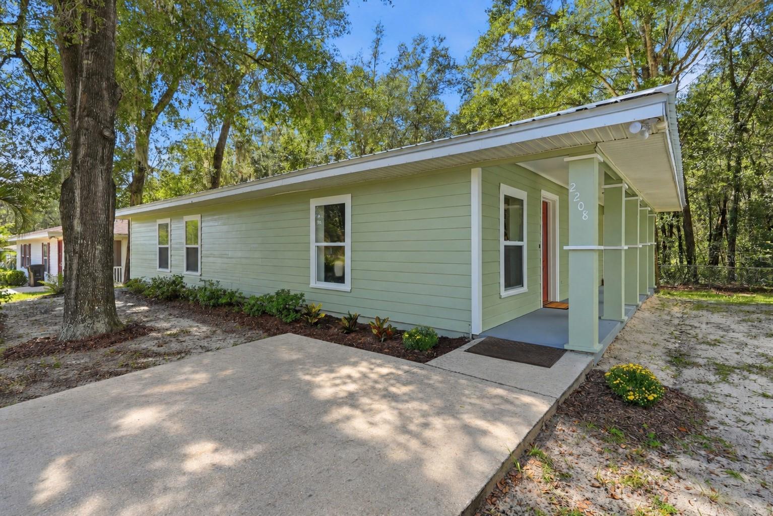 Move-in ready 3BR/2BA built in 2005 with the big-ticket items already done: NEW ROOF (2026), NEW HVAC (2026), NEW WATER HEATER (2026). Open living and dining area, luxury vinyl plank flooring throughout the main living spaces, and new carpet in all three bedrooms. Kitchen offers stainless steel appliances, butcher-block countertops, refinished cabinetry, and a new faucet. Both bathrooms have been fully updated with new vanities, fixtures, lighting, and tub/shower surrounds. Primary suite features a barn door to the en-suite bath. Fresh interior and exterior paint, new ceiling fans and light fixtures, and an indoor laundry room with shelving. Covered front porch, metal roof, and a large, shaded backyard with mature trees. Minutes to downtown Gainesville, UF, and Shands via SE Hawthorne Rd.